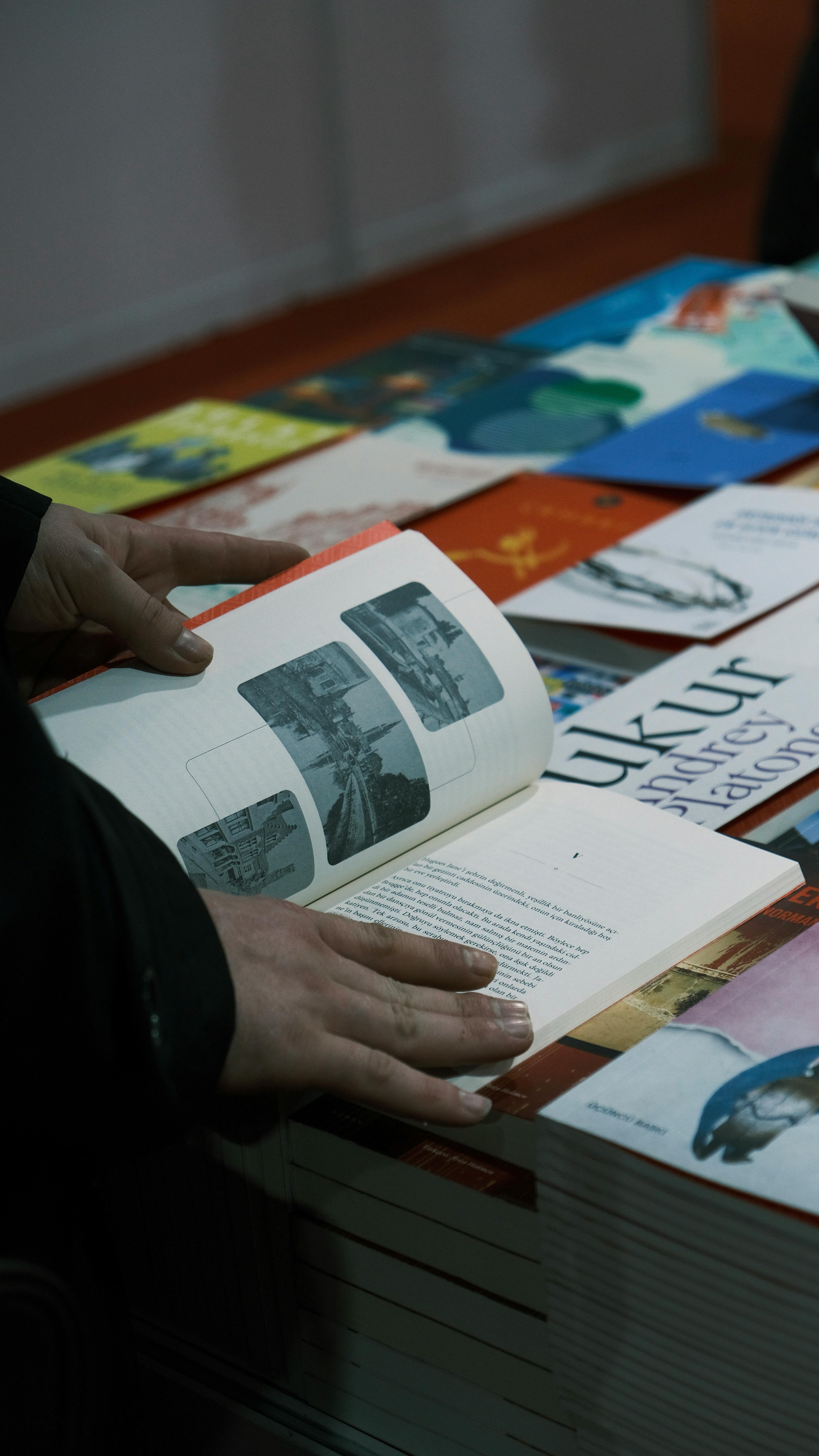 a-person-browsing-through-various-books-at-an-indoor-market-stall,-viewing-photo - ebuyıldız (pexels)