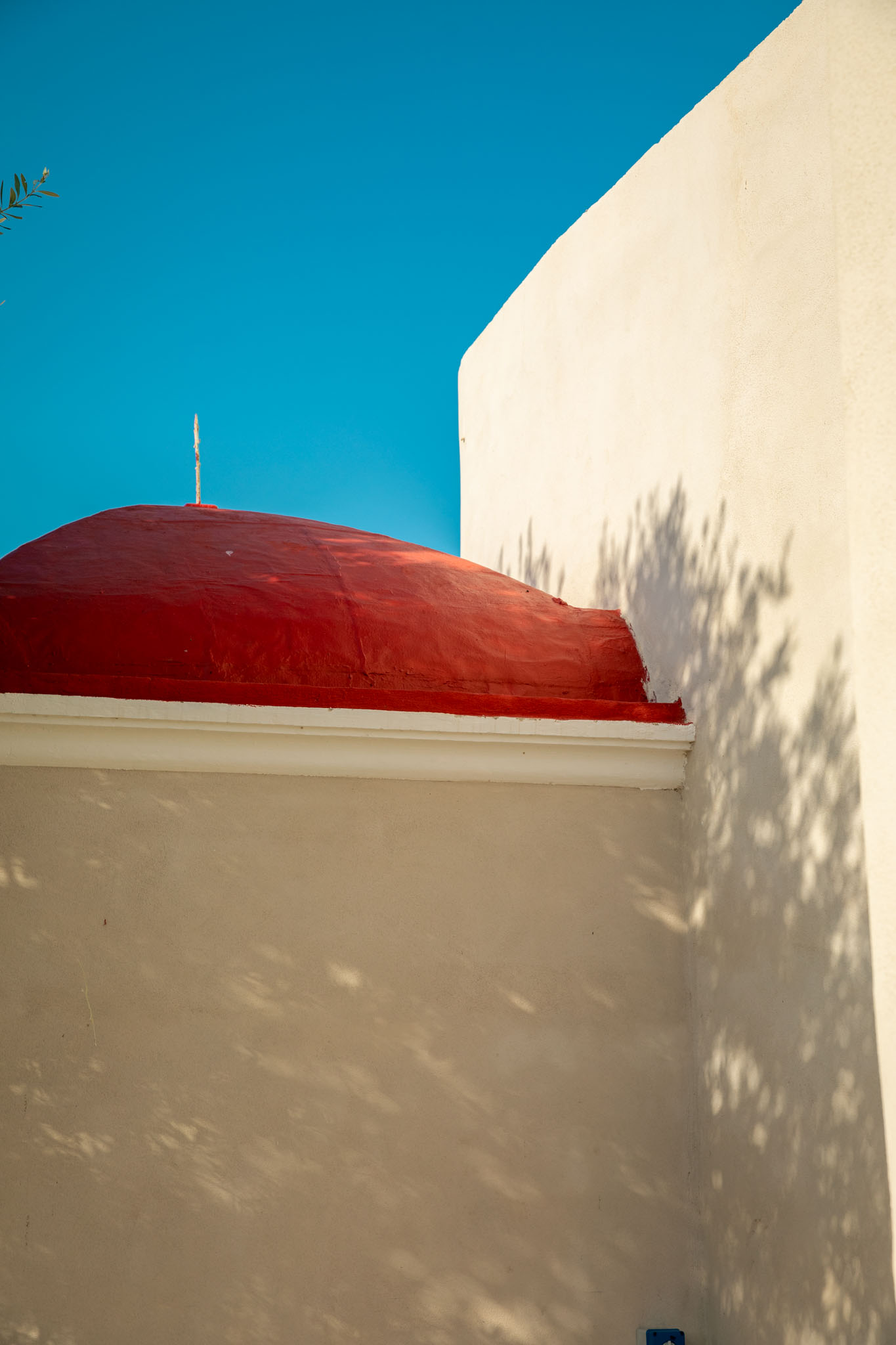 A person with shoulder-length blonde hair wearing a black newsboy cap and a black sweater.