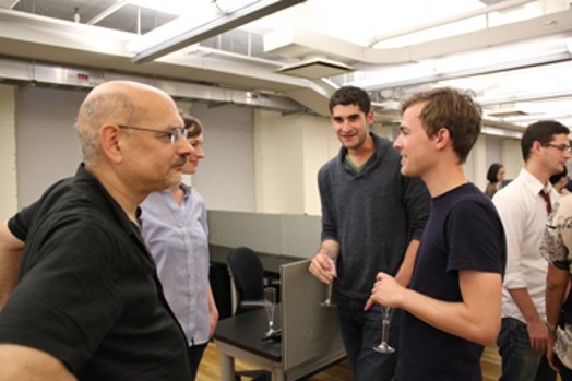 a group of men is talking in a well-lit room