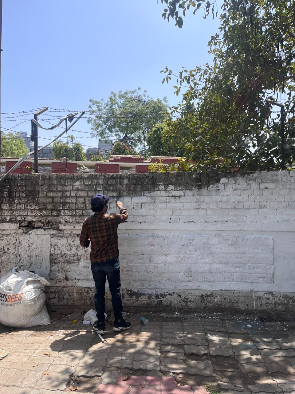 Modern home office setup with a monitor, ergonomic chair, keyboard, and indoor plants near a window with blinds.