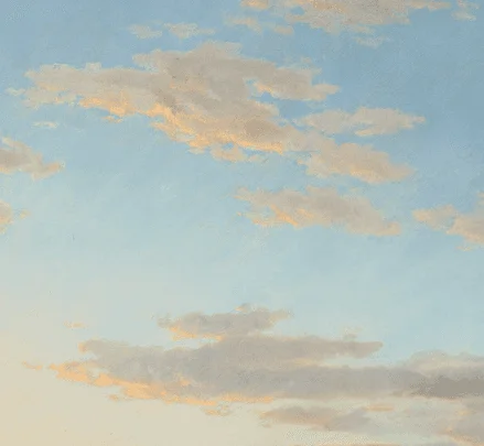 Soft clouds drifting across a pale blue sky.
