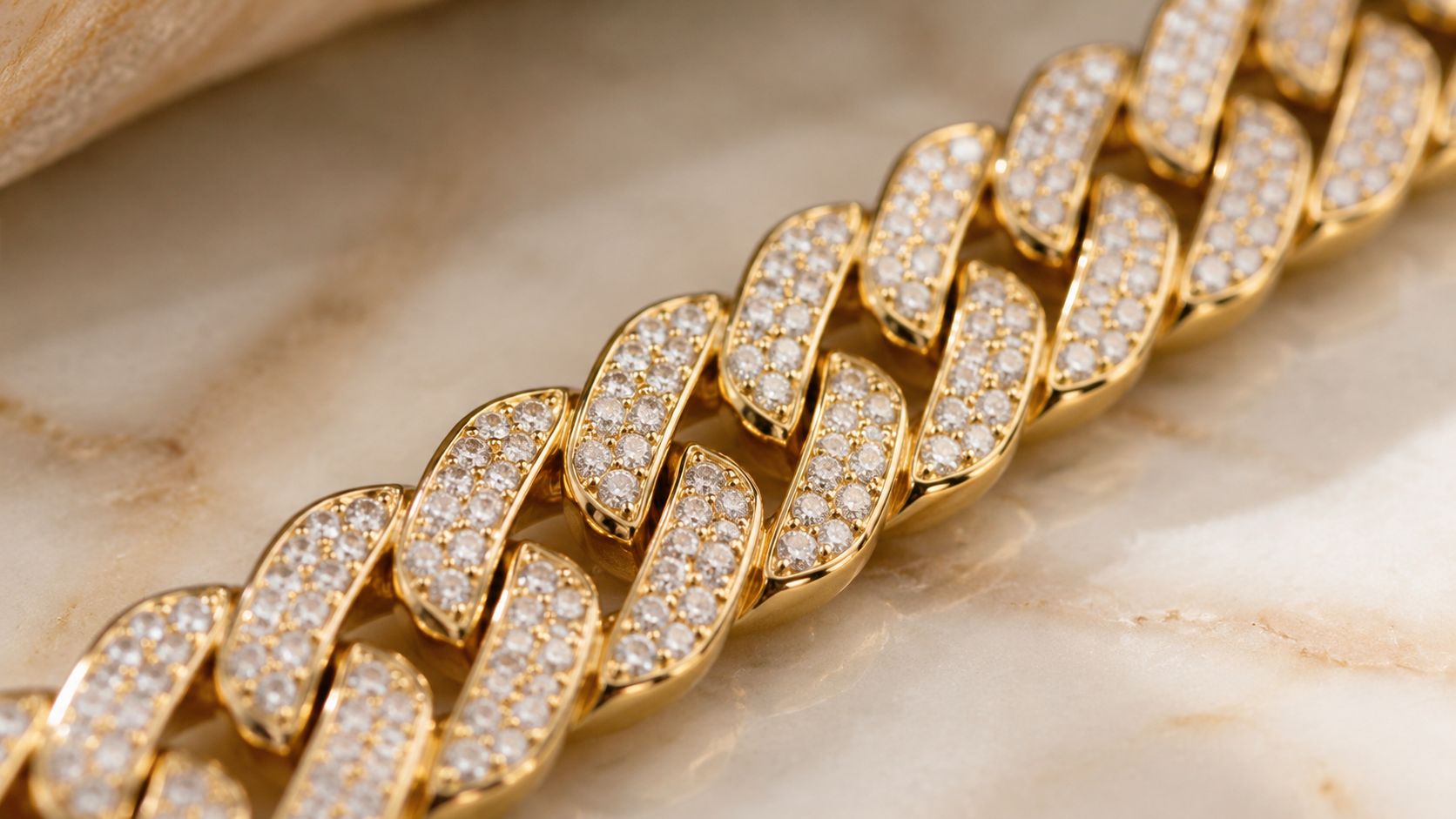 A close-up view of a gold cuban link chain encrusted with small sparkling diamonds.