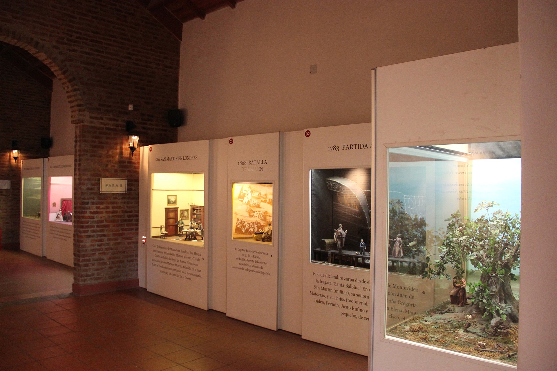 Pasillo de museo con paneles temáticos y dioramas sobre eventos históricos de Argentina.