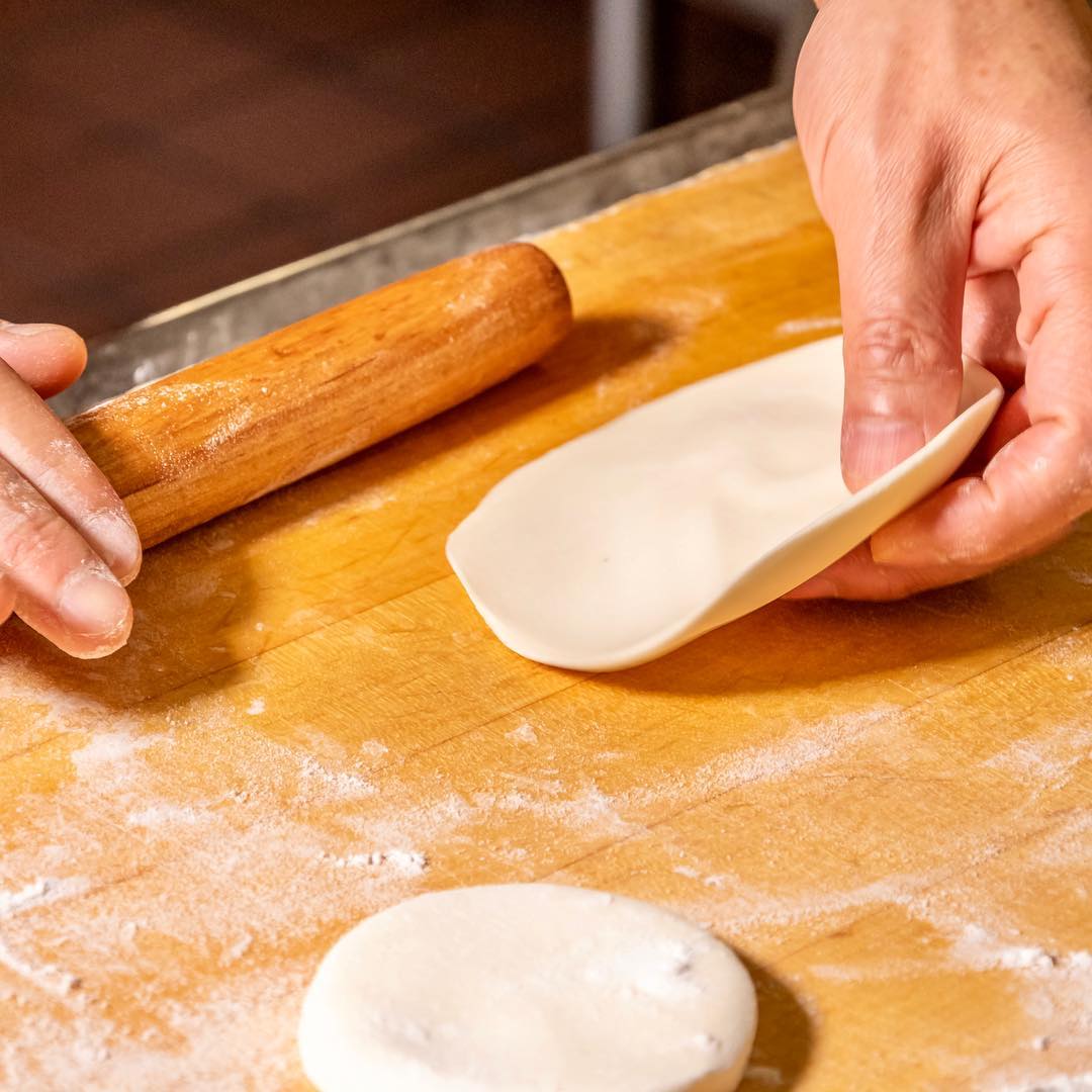 A chef expertly pulling noodles by hand in the kitchen, capturing the artistry and tradition behind China Islamic Restaurant’s signature dishes.