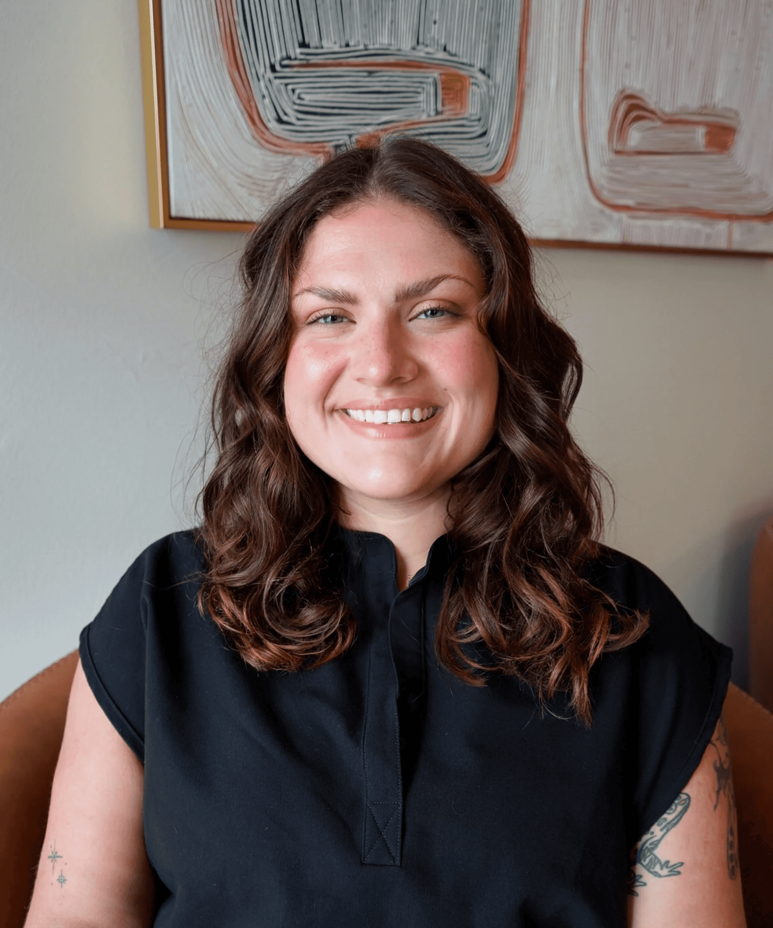 Emily Biscoe in leather chair with cowboy painting in background