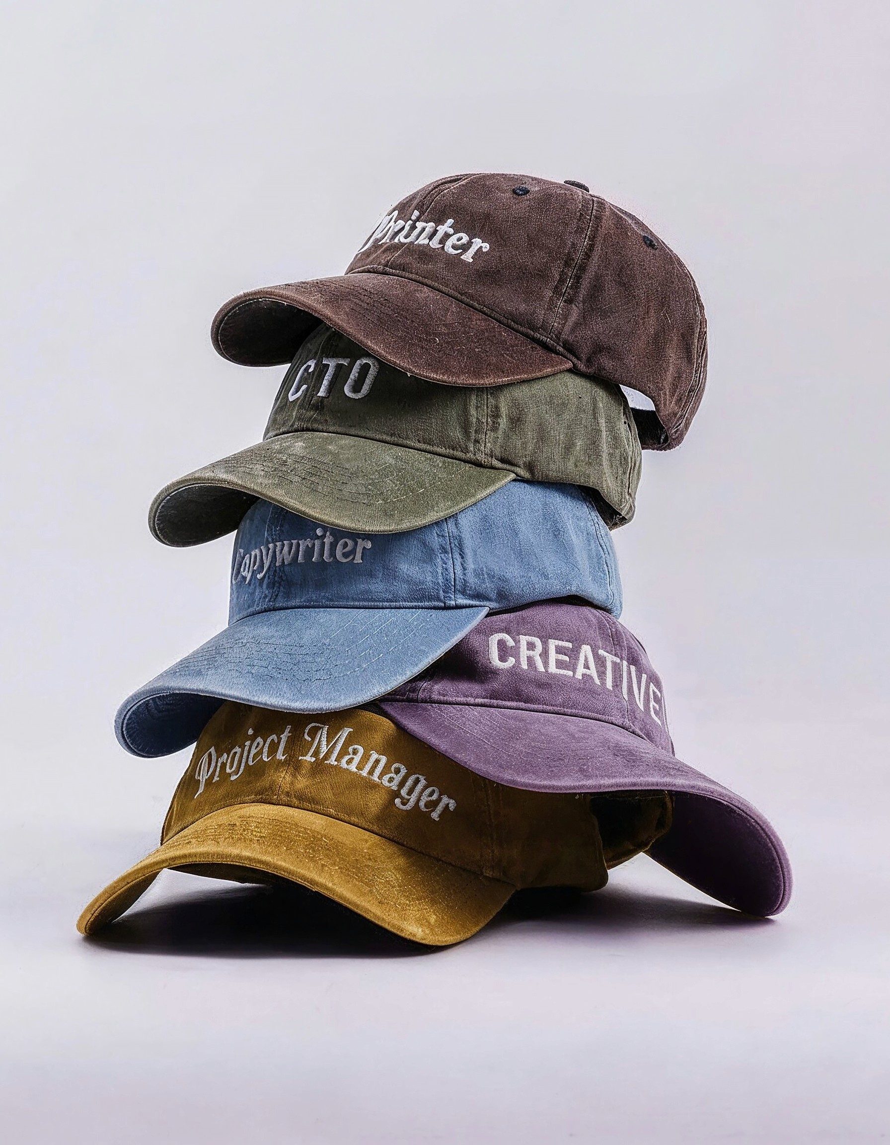 Man wearing multiple caps stacked on his head, symbolising multitasking and versatility in creative roles, against a bright blue background.