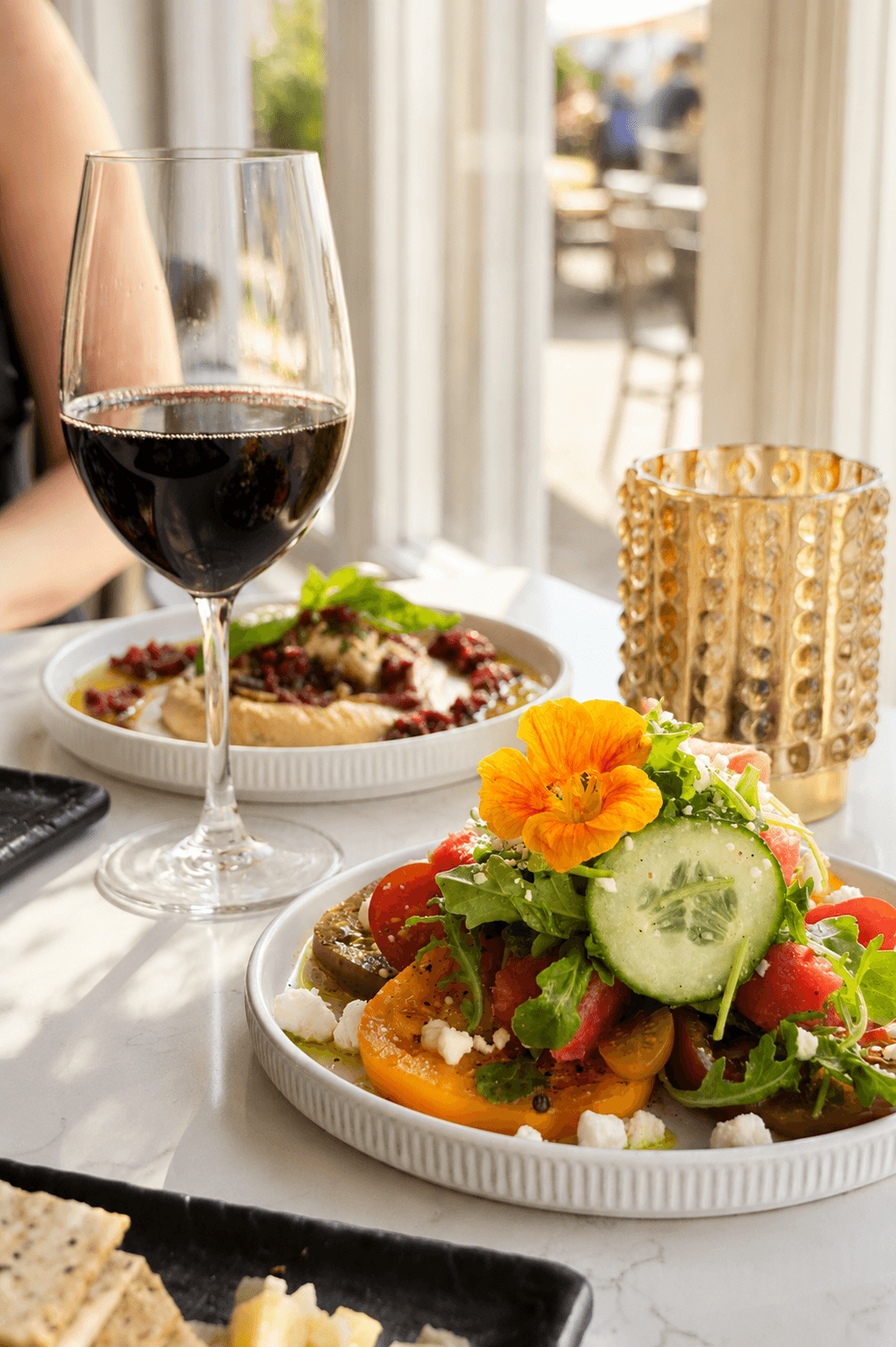 Fresh dishes and wine beside lake-facing windows