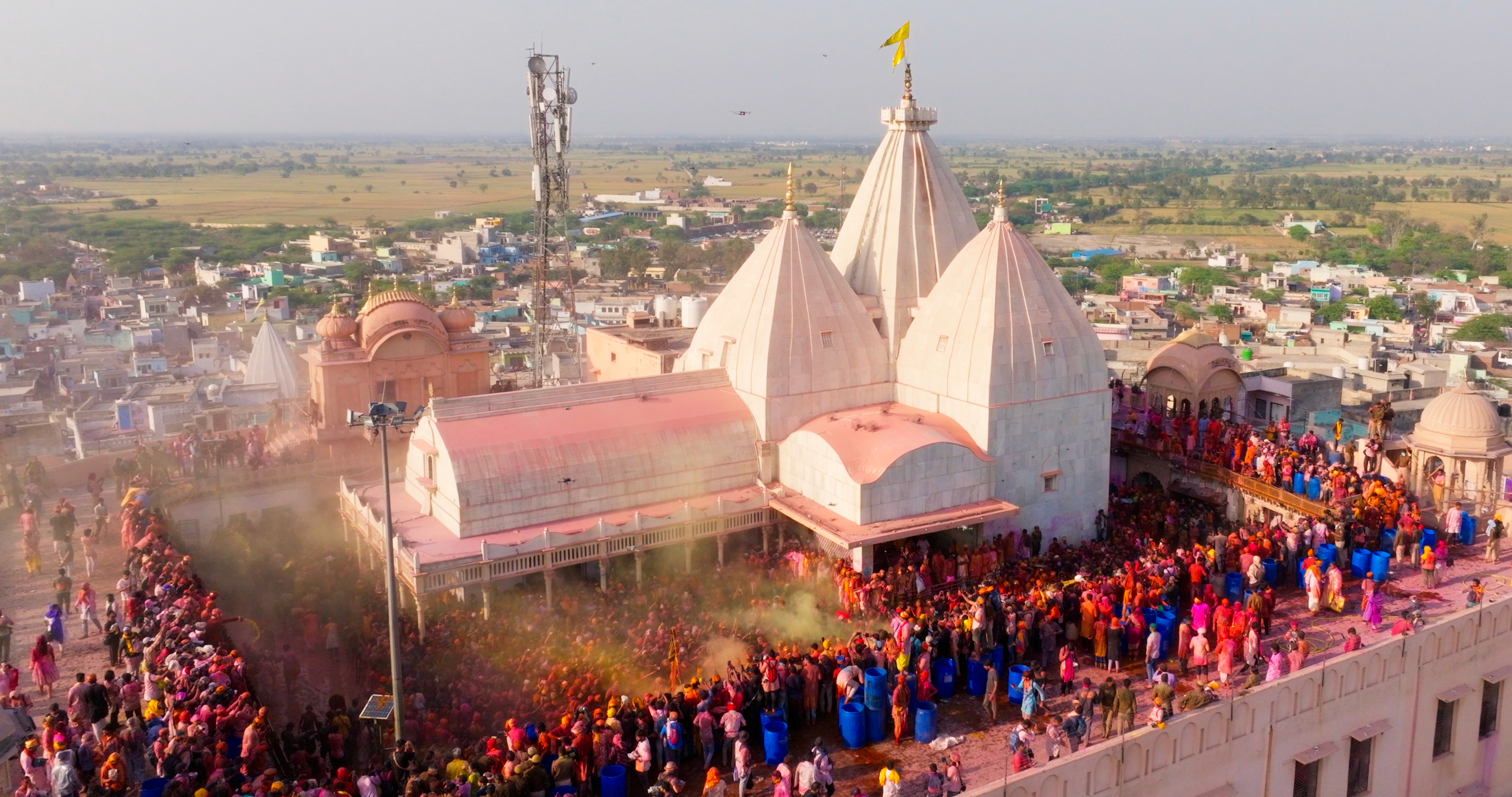 Drone view of the temple and thousands of people covered in colored powder