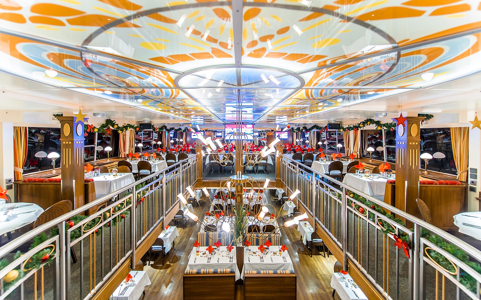 Interior de un comedor decorado en un crucero nocturno por el Danubio con mesas preparadas para la cena.