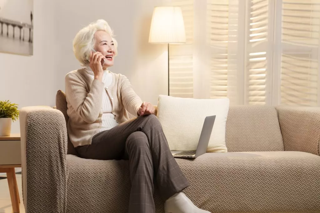 Lady sat on sofa on mobile phone image