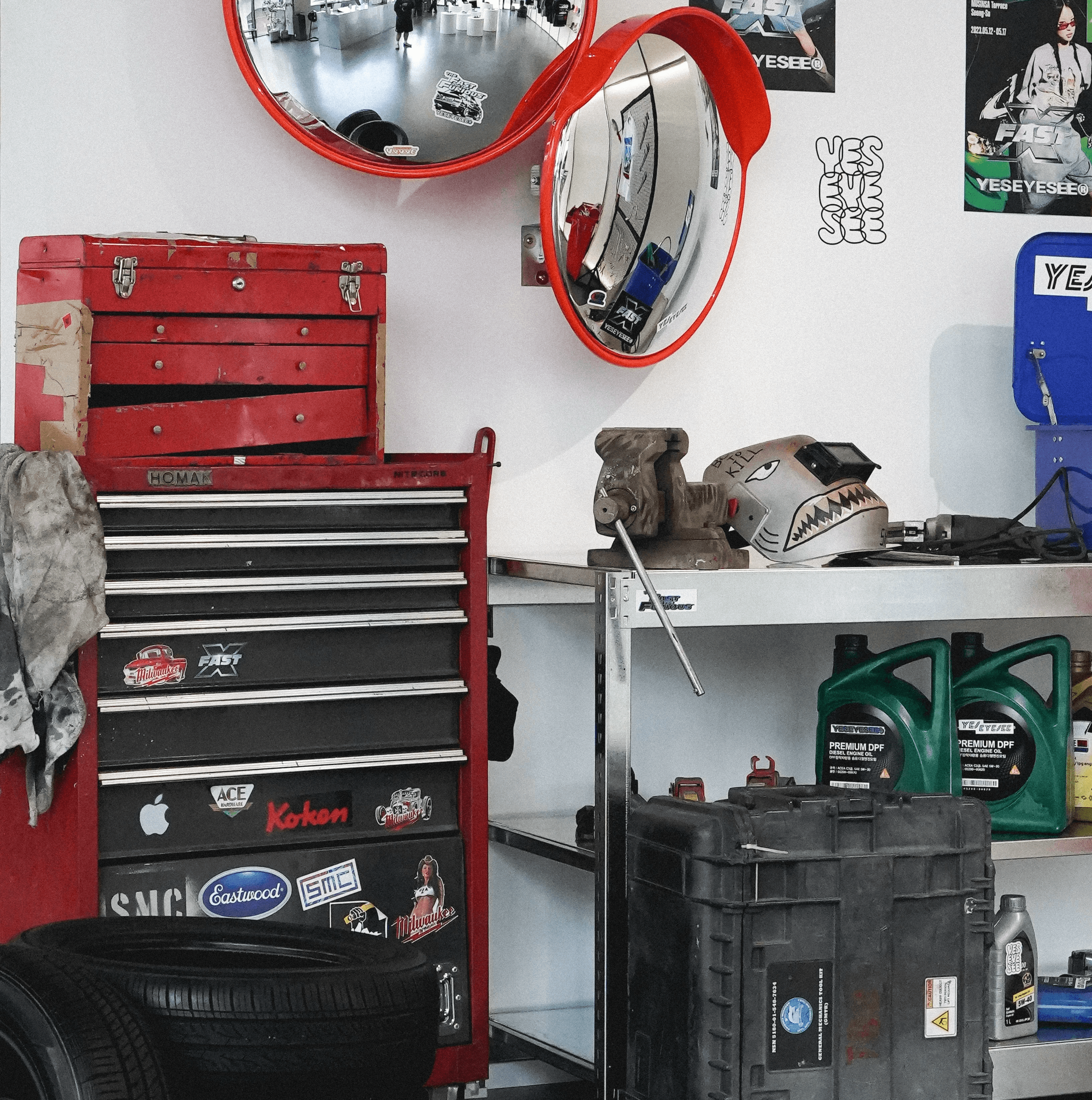 YESEYESEE × Fast & Furious 팝업스토어 전경, 흰색 원형 전시대와 개러지 테마 오브제 배치 전체 공간 / Full overview of the YESEYESEE × Fast & Furious pop-up with white cylindrical pedestals and garage-concept object staging