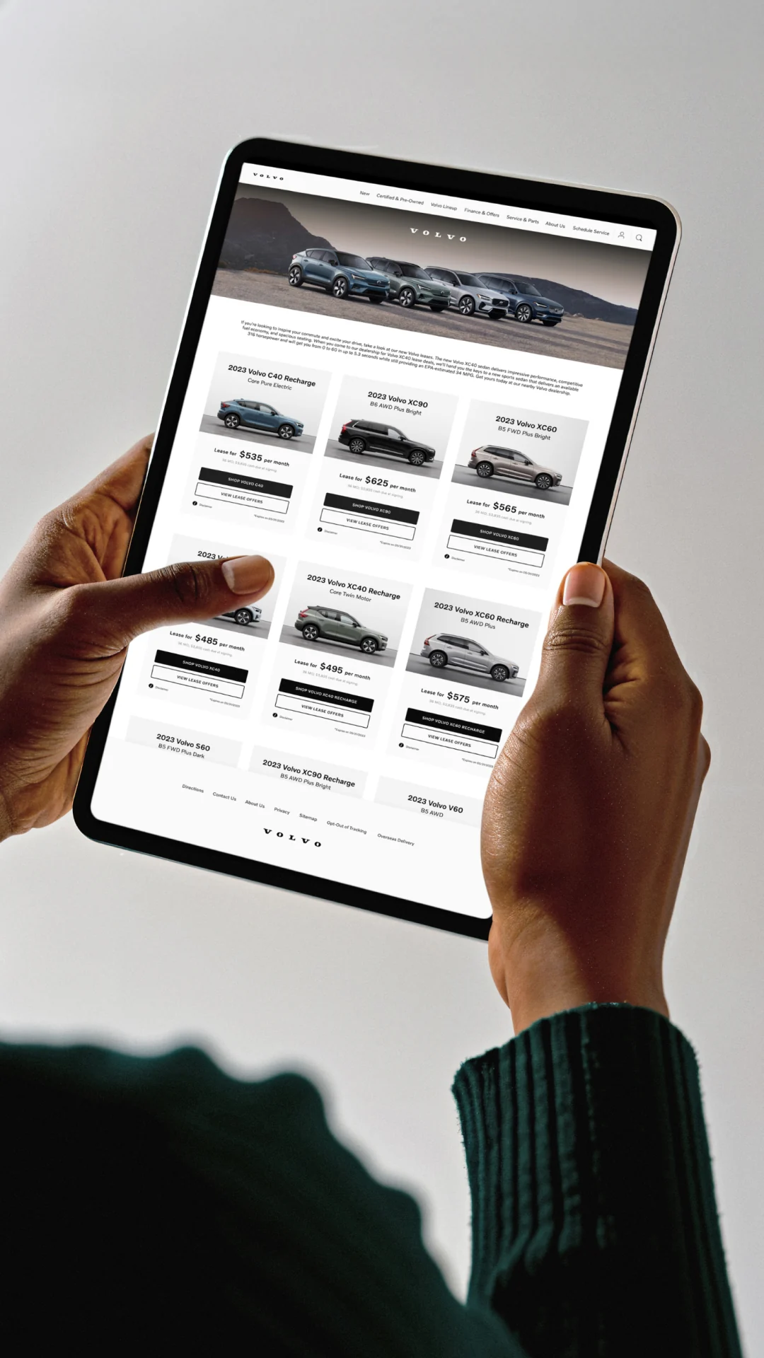 Volvo — Hero photo of person holding iPad with Volvo webpage design — UI/UX application