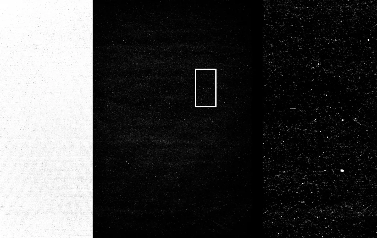 Close-up detail of black paper texture showing scratches dust and worn surface