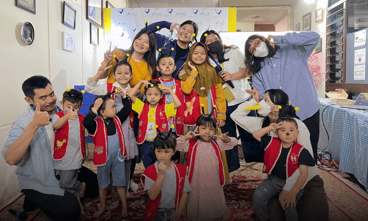 person in gray hoodie holding red and white box