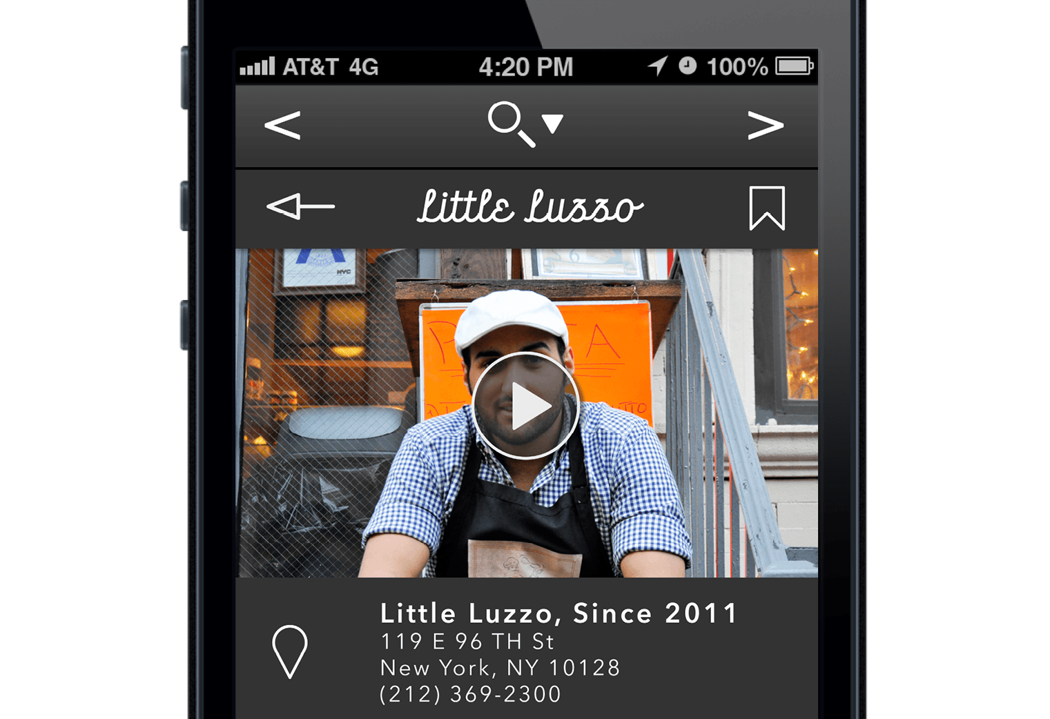 The image shows a smartphone screen displaying a video titled "Little Luzzo," which is part of a series called "Little Luzzo, Since 2011." The video features a man wearing a white cap and a blue and white checkered shirt, wearing a black apron. He is standing in front of a building with an orange sign behind him. The phone’s status bar indicates it is 4:20 PM, the carrier is AT&T 4G, and the battery is at 100%. The video interface includes a play button, a back arrow, a forward arrow, and a bookmark icon. Below the video, a location pin icon is visible, followed by the text "Little Luzzo, Since 2011" and a street address: "119 E 96th St, New York, NY 10128." The phone also displays a contact number (212) 369-2300.