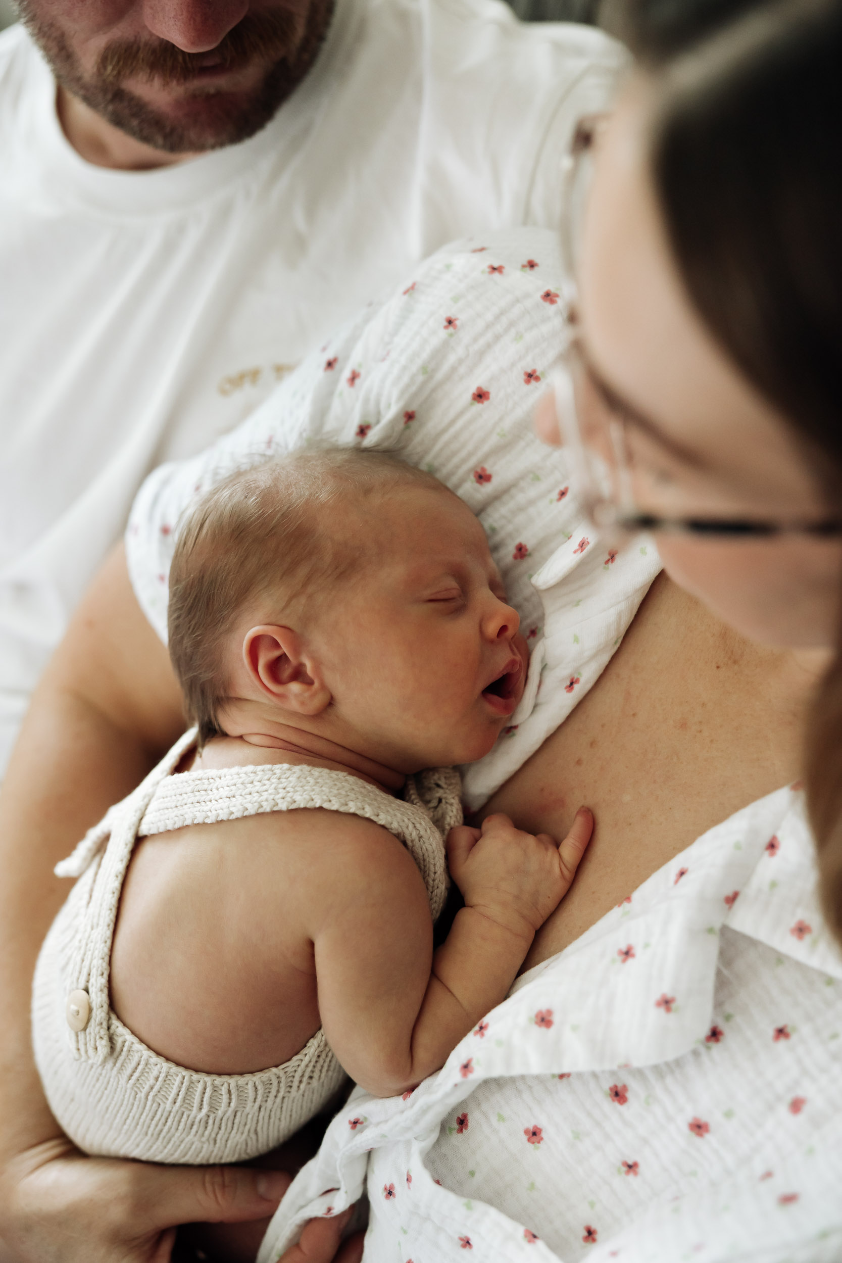 Mother cuddling sleeping newborn baby