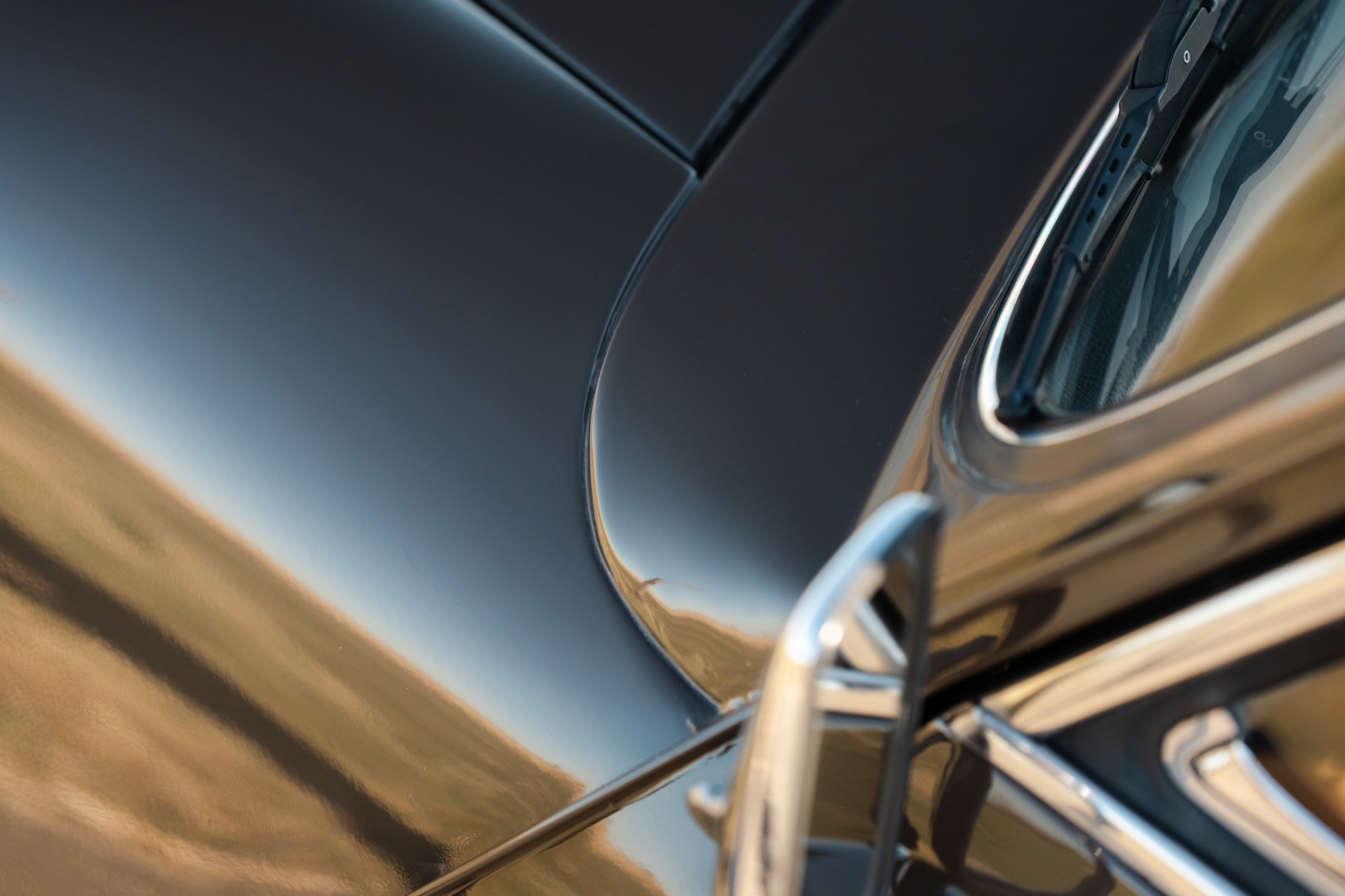 Close-up of sleek, curved surfaces against a horizon with a gradient of blue and brown tones.