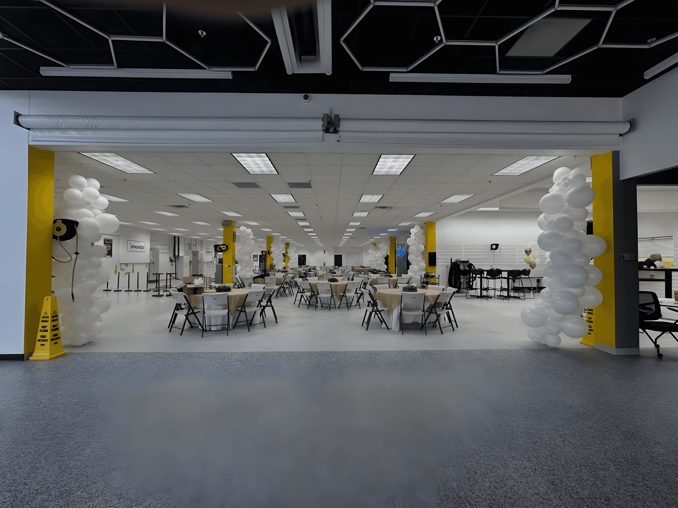 Large open event space with white and yellow pillars prepared for a Be Bold Balloons setup or decoration installation