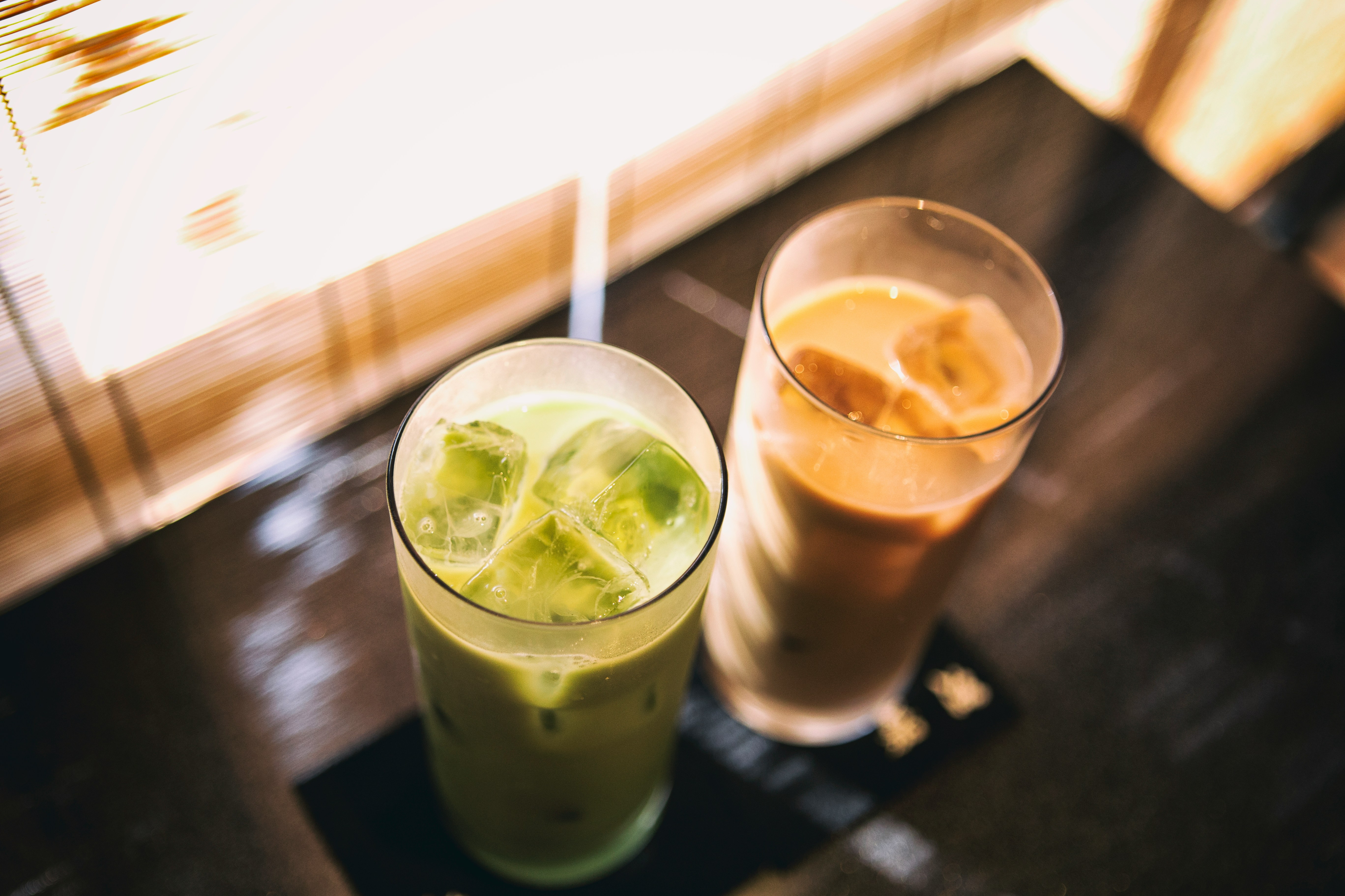 two glass cups with cold beverage inside