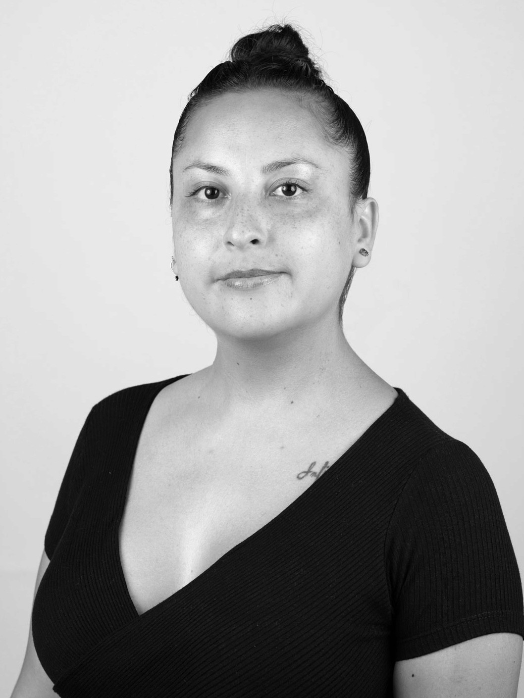 Retrato en blanco y negro de una mujer con el pelo recogido y camisa negra
