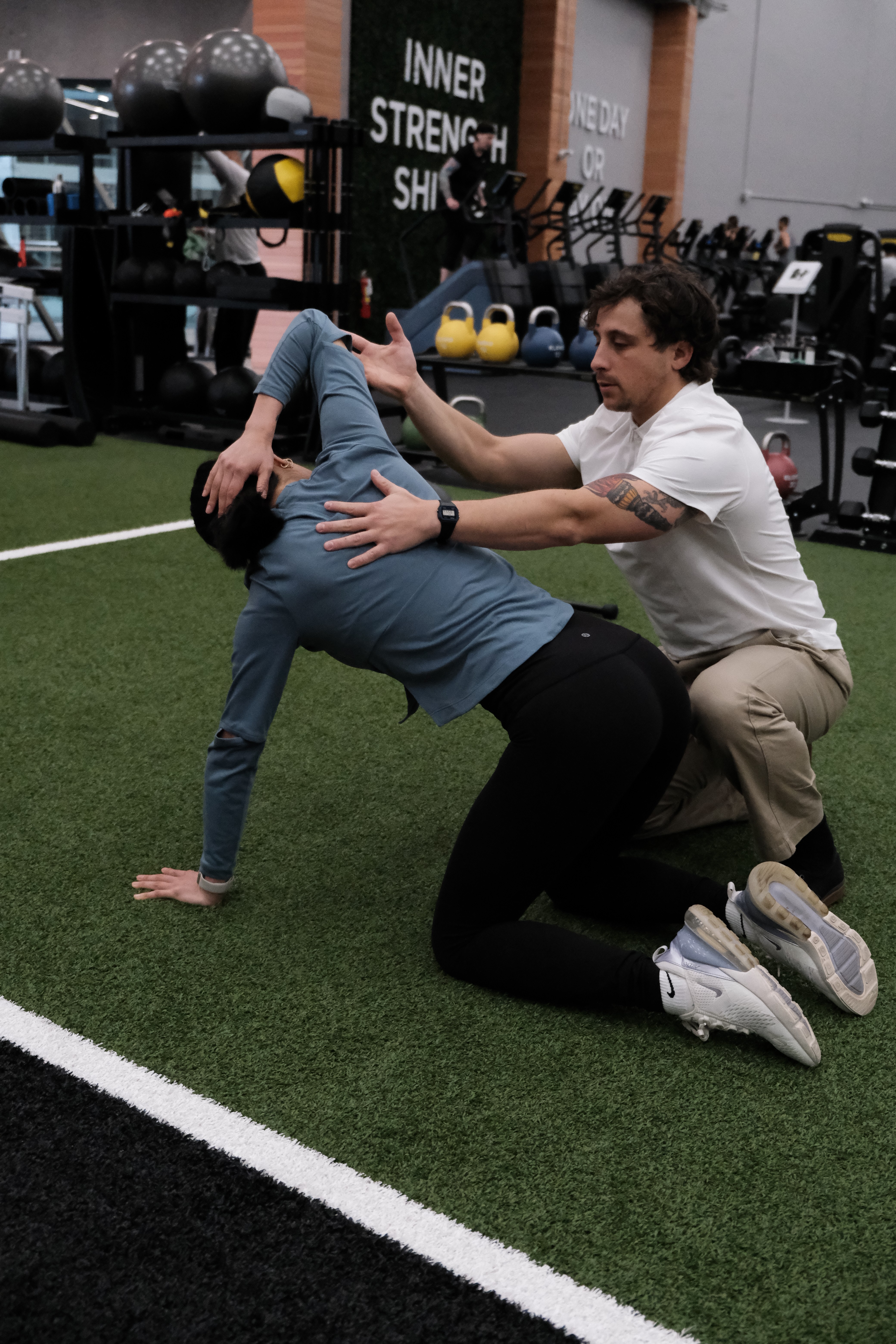 physiotherapist correcting and cueing a patient's movement pattern