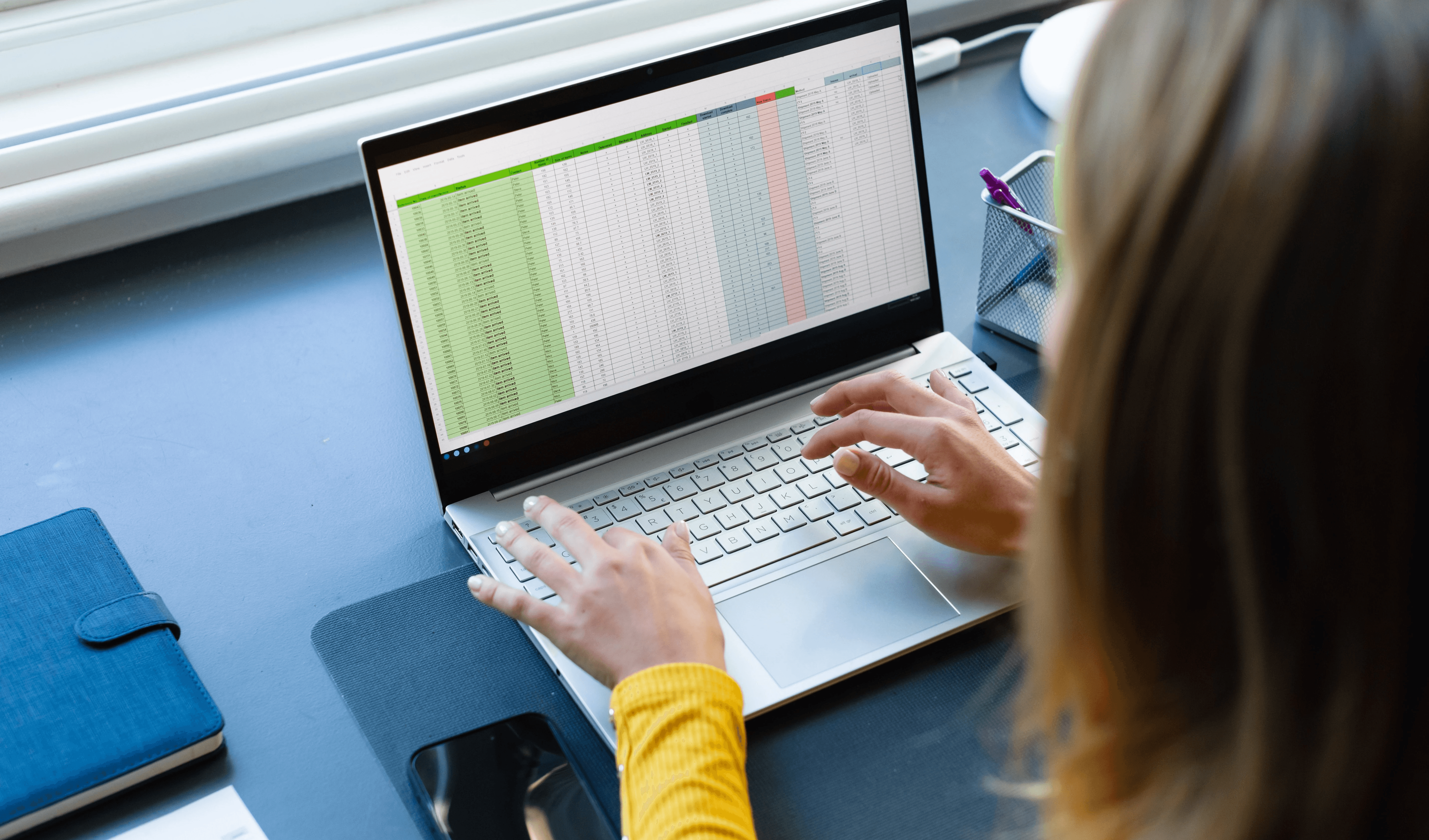 Woman working on a laptop spreadsheet - How to Automate Excel Reports
