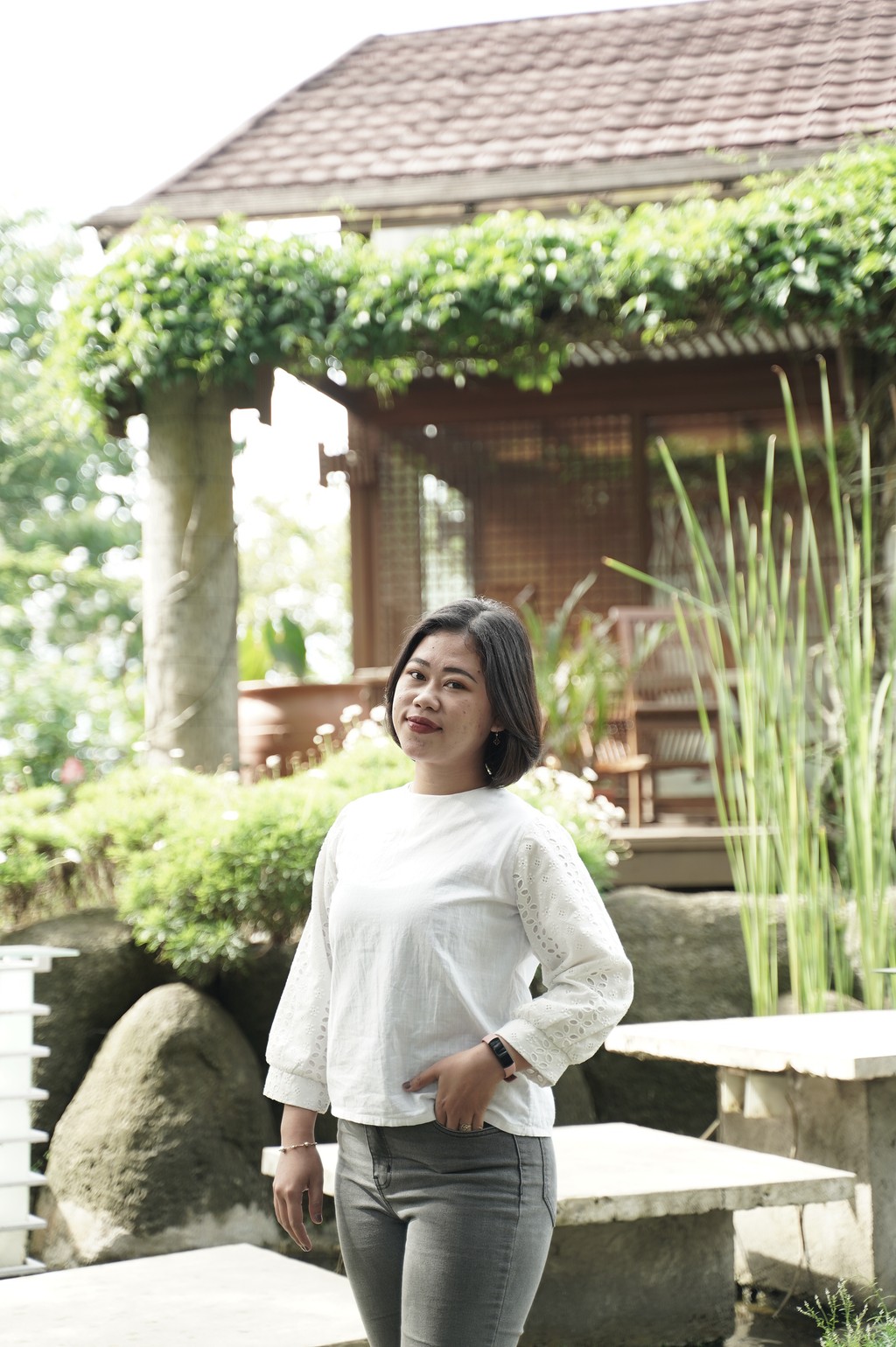 A winding road cuts through rocky terrain, surrounded by patches of green grass and illuminated by sunlight.