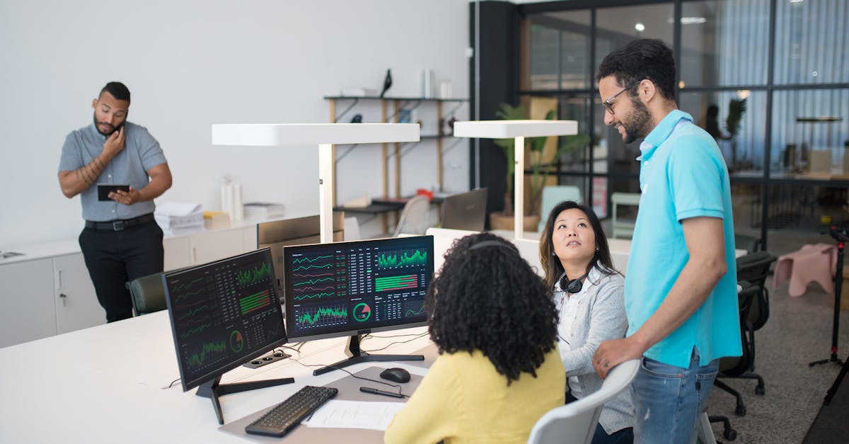 Office employees collaborate on financial data at modern workspace, engaging in teamwork and communi