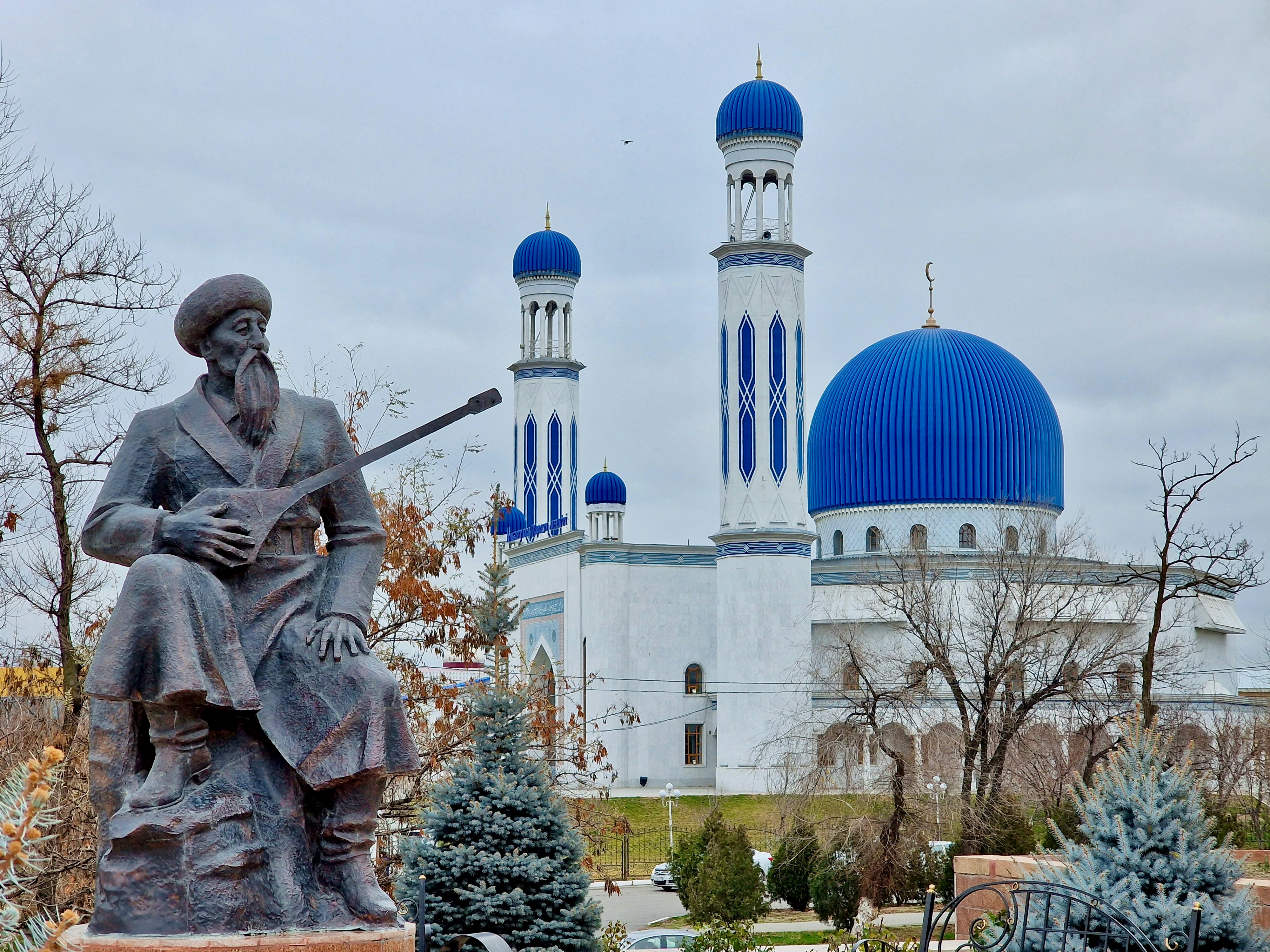 a statue of a man holding a rifle in front of a building