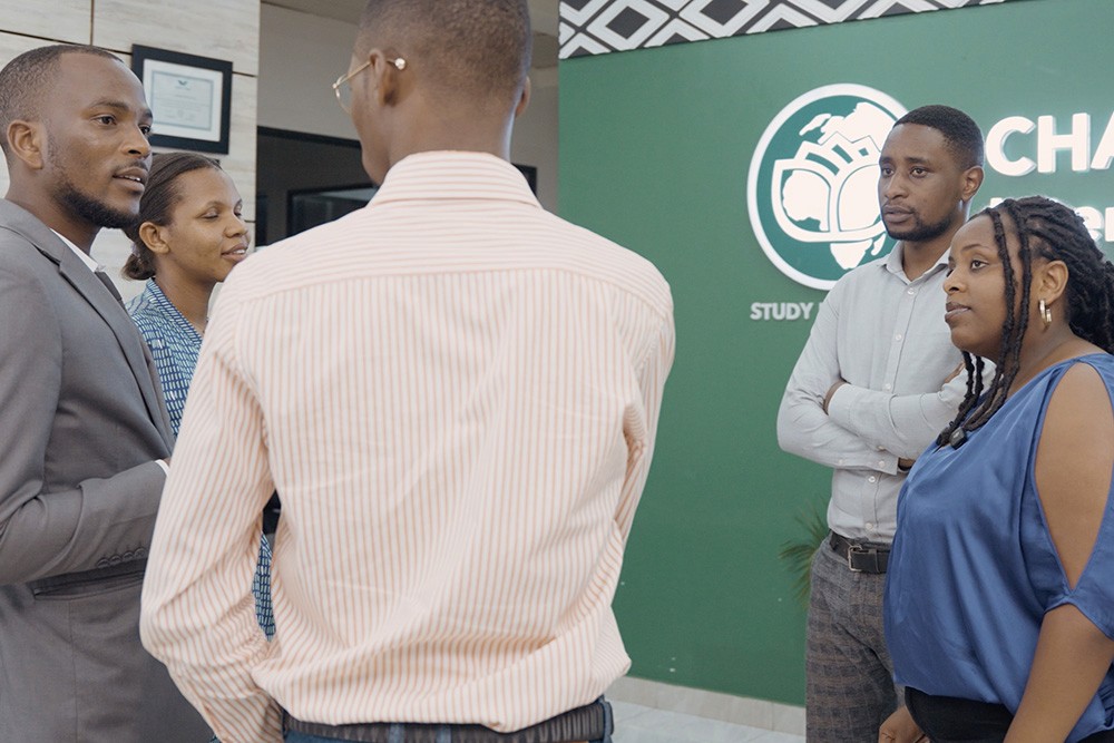 Chancen International team members talking together in front of a branded office wall