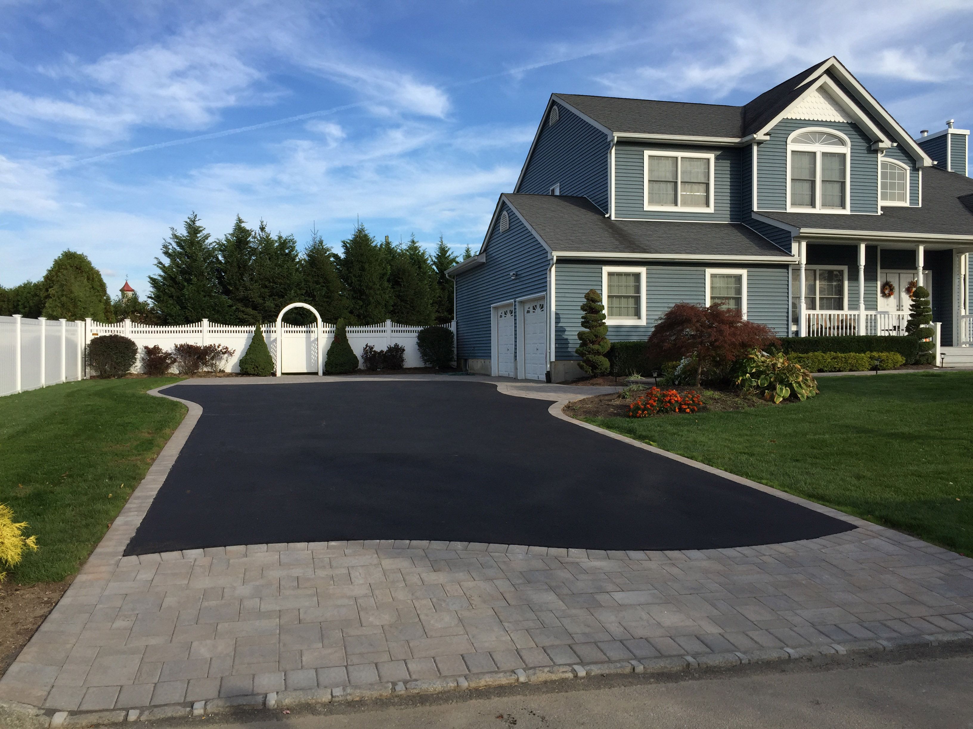 A paved driveway in front of a modern home
