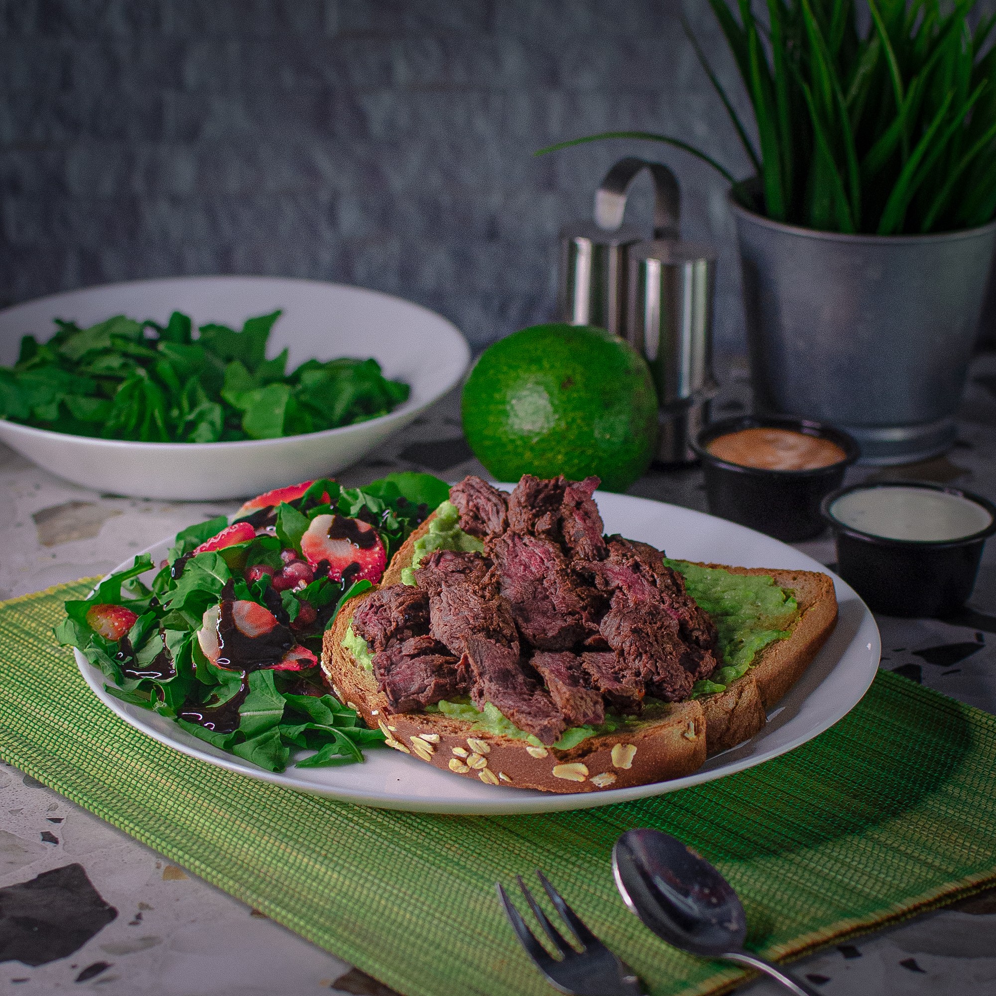 A beautifully arranged table with various dishes, including fruits, bread, and wine, set for a meal.