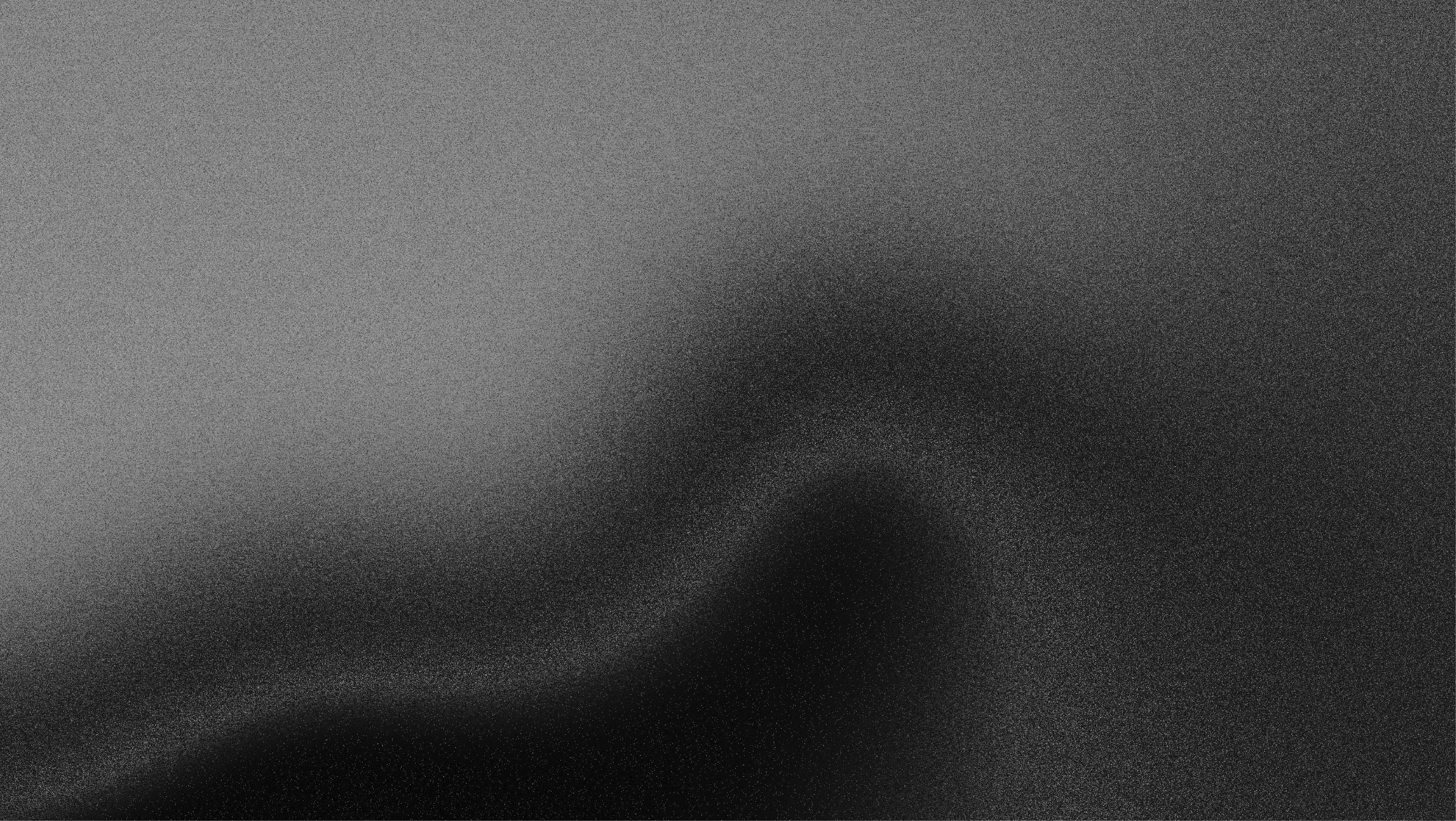 A gradient image transitioning from dark black to light gray tones.