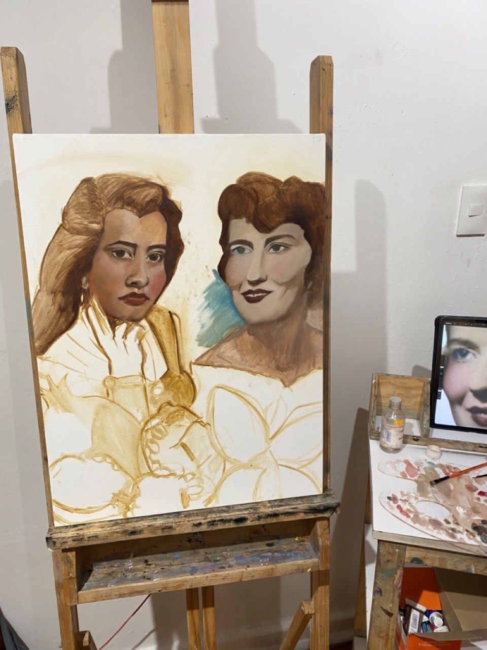 A view from an airplane window shows the aircraft's wing with a golden hue reflecting the setting sun, against a serene backdrop of fluffy clouds and a clear sky.