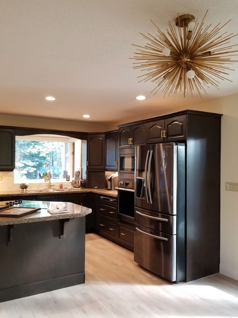 Image of KHD Homes kitchen design with dark cabinets, stainless steel appliances, and modern lighting fixtures interior design.