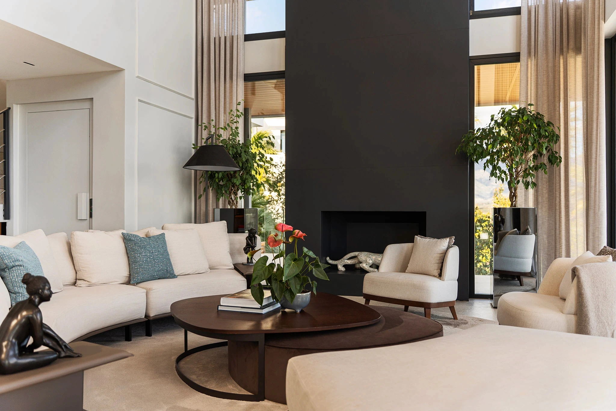Villa Vista Marbella living room with curved sofa, black feature fireplace wall, and round coffee tables