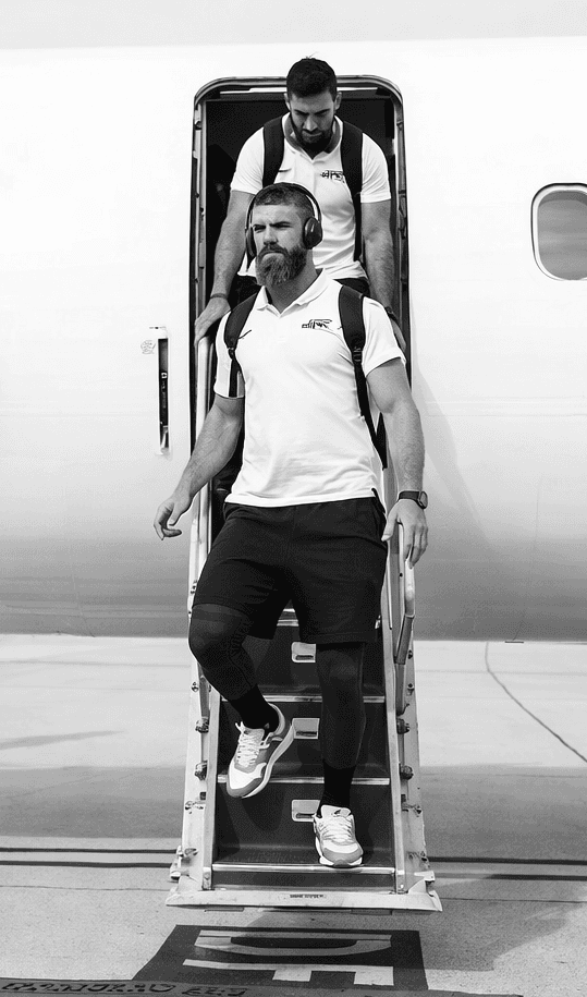 A rugby sports team walking off a plane