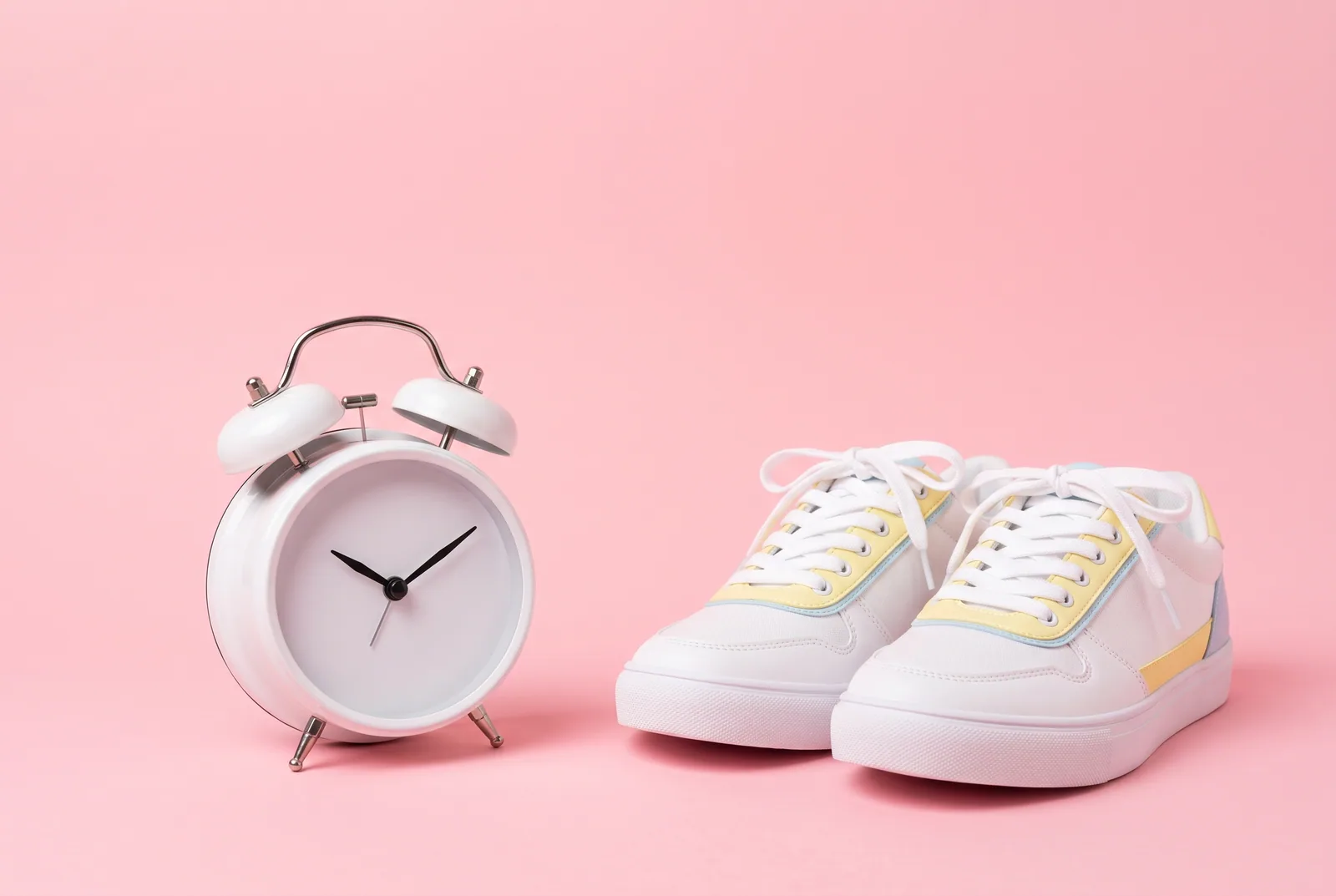 Steps to stop watching porn as a teen: a vintage alarm clock beside a pair of sneakers on a pastel pink backdrop