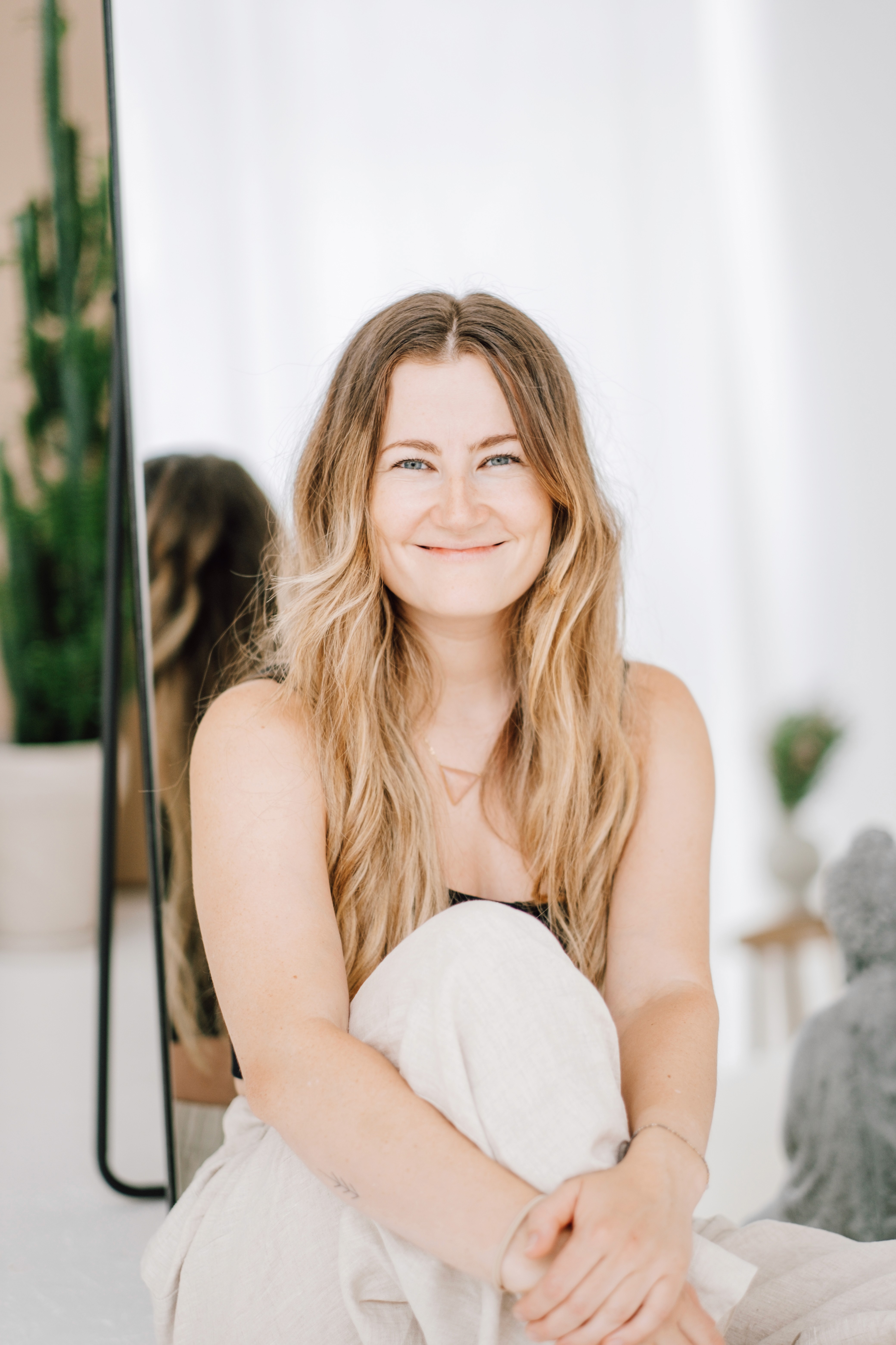 Antonia lächelnd mit Armen über dem Kopf auf Wiese