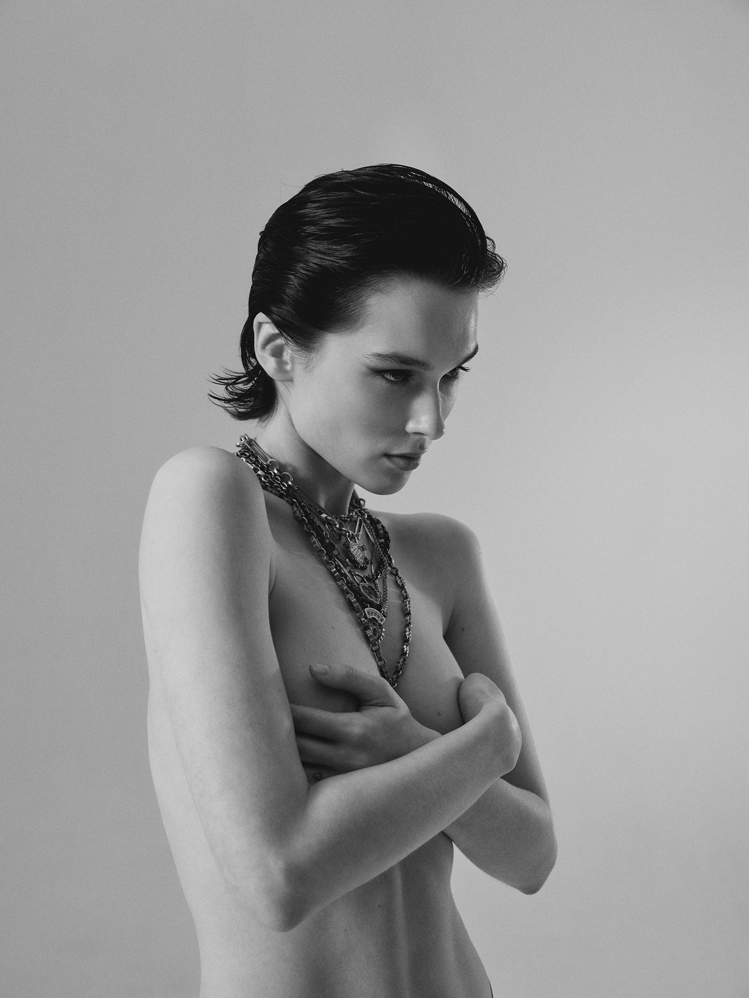 Black-and-white studio portrait of a woman with crossed arms.