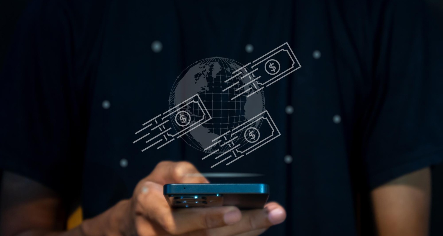 A person holding a smartphone with an illustrated hologram above it, showing a globe surrounded by fast-moving dollar bill icons, symbolizing the movement and concealment of funds during the layering stage of money laundering.