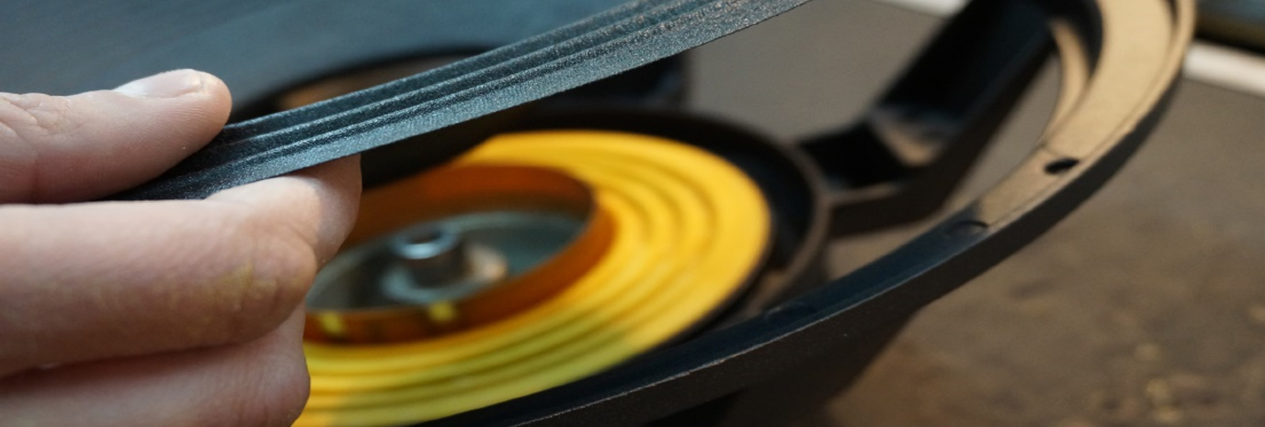 Speaker cone surround being held by a finger.
