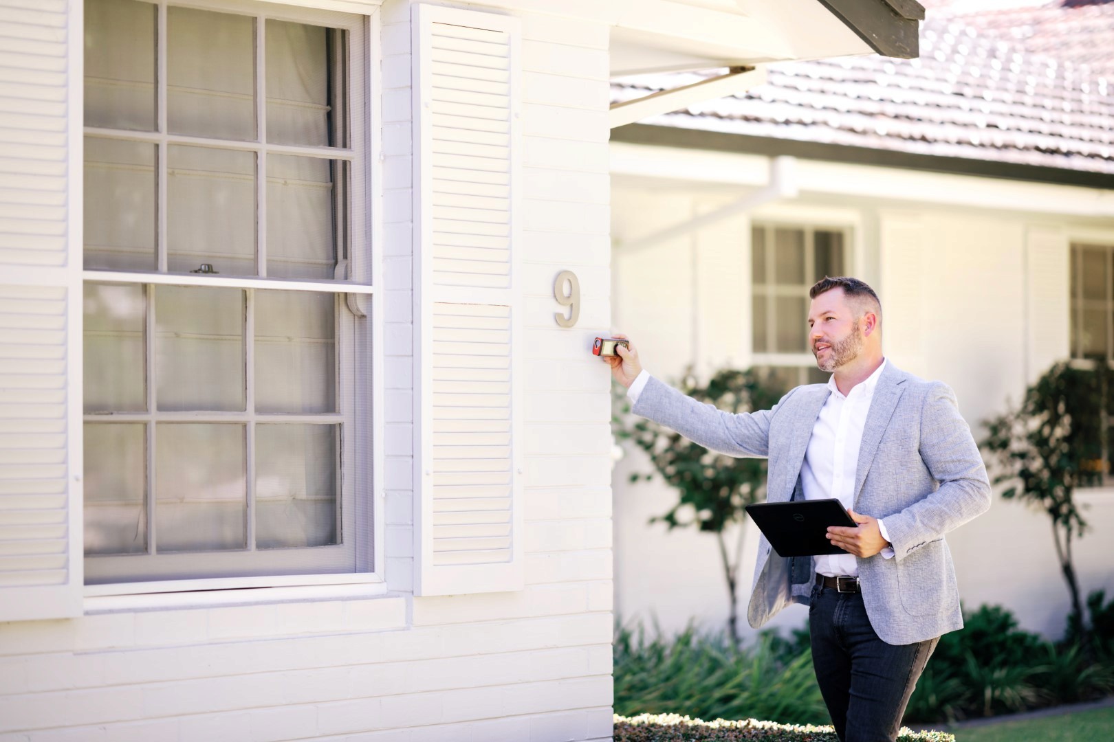 Blake inspecting a house using a laser measuring device