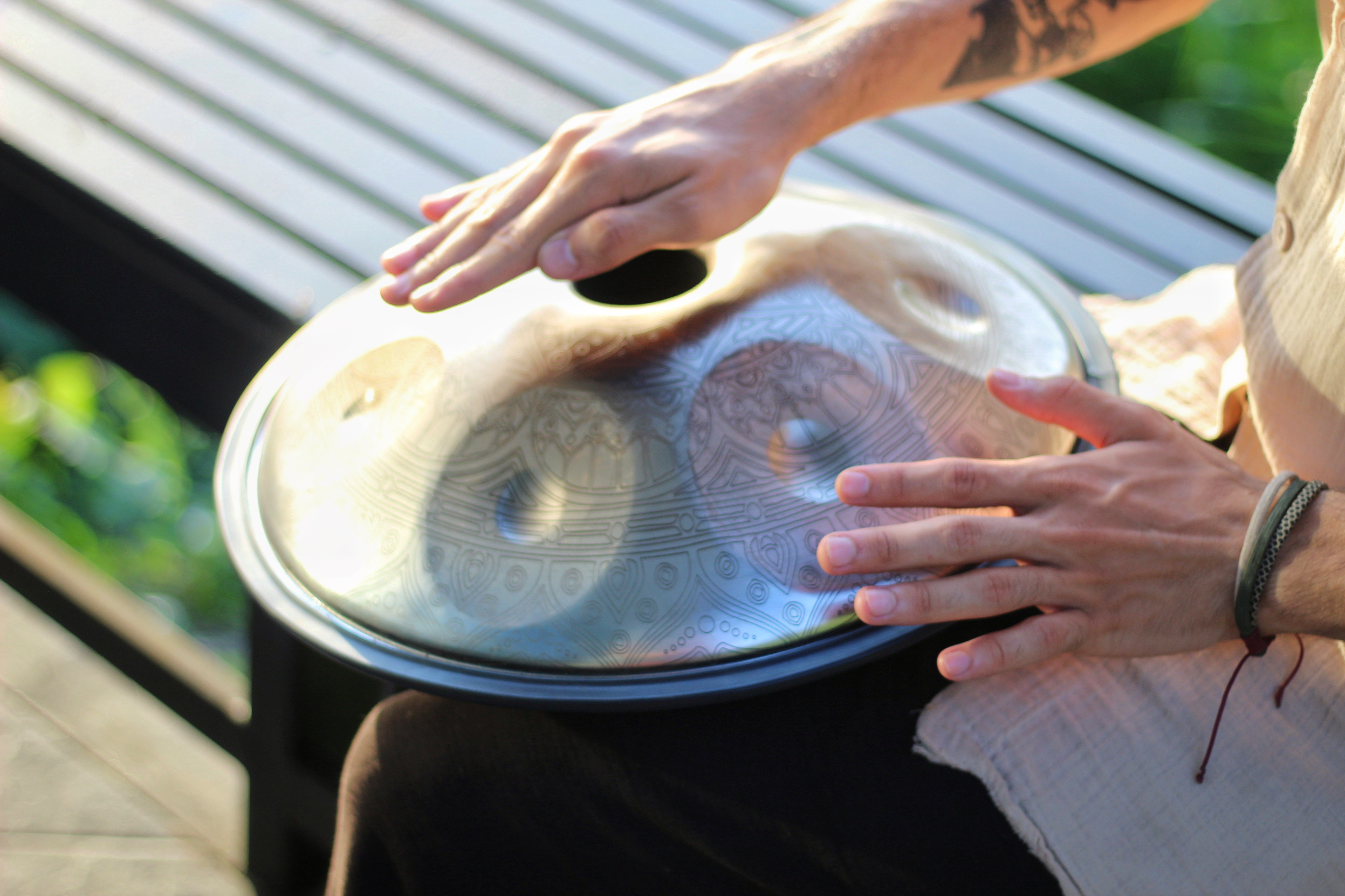 Someone is playing the handpan on his lap.