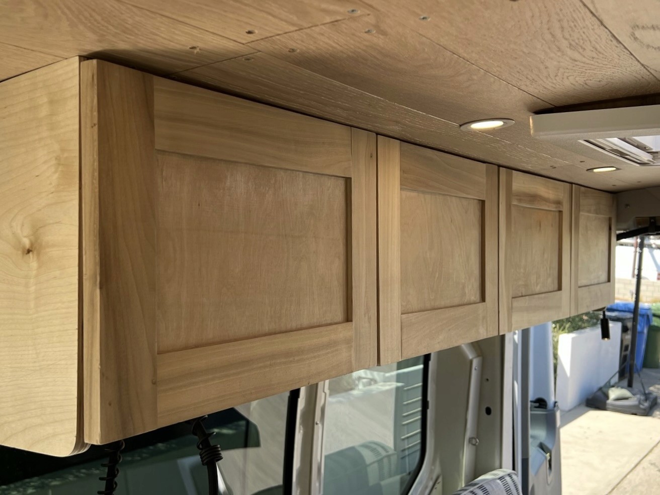 Custom wood overhead cabinets inside a van