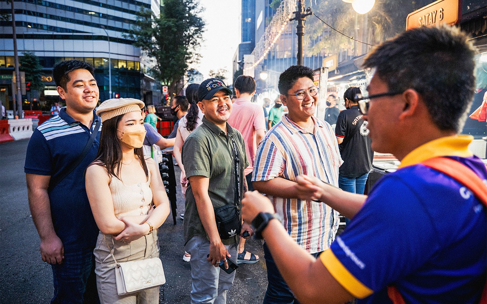 Hawker stalls with diverse dishes at Singapore night market during street food tour.