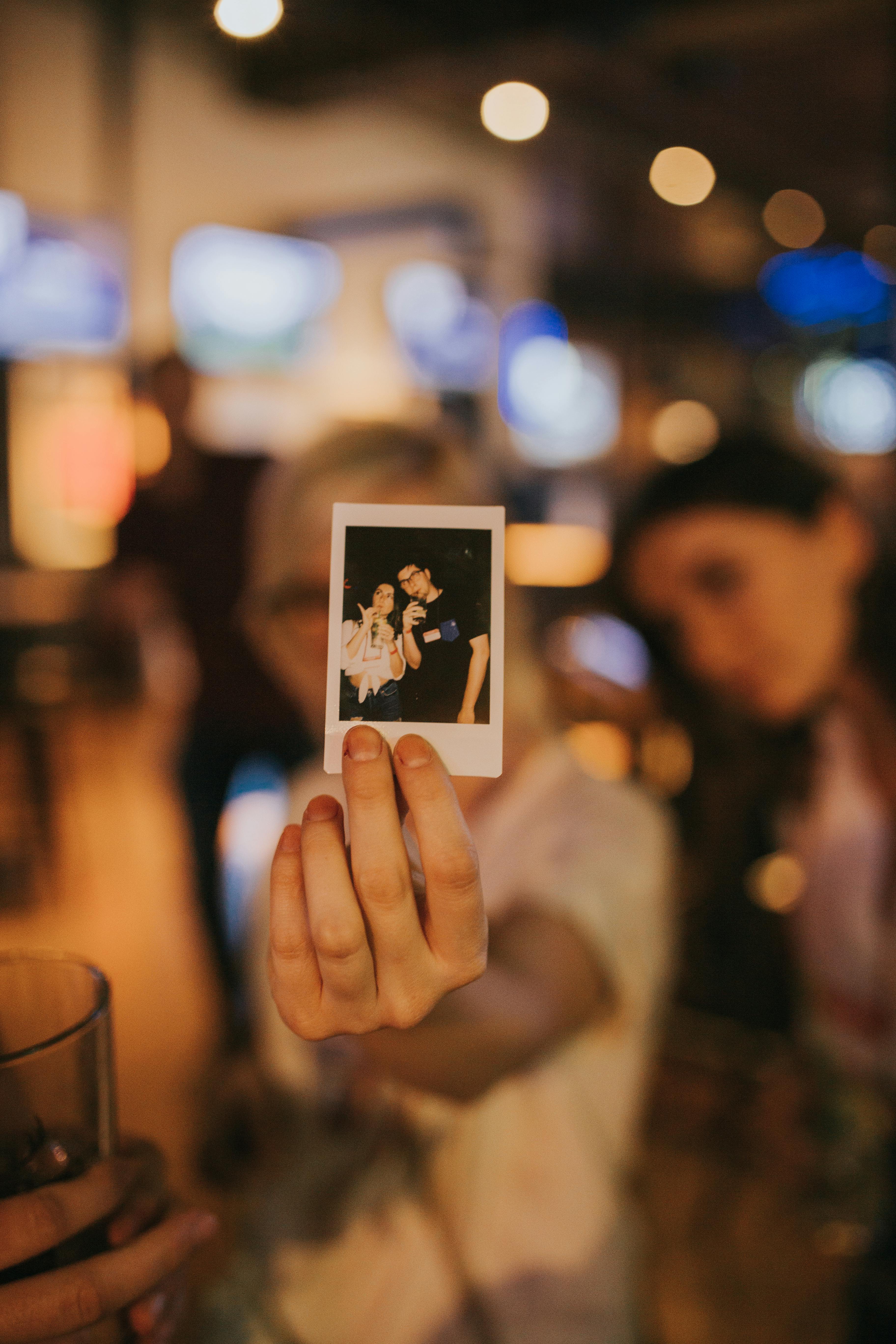 a-hand-holds-a-polaroid-picture-in-a-lively-denver-setting. - nicole-sabilia (pexels)