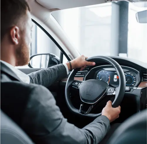 man in black t-shirt and brown hat driving car