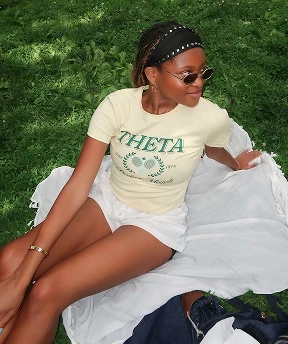 Alex Ruff styling a fitted Theta sorority baby tee as a casual athletic outfit.