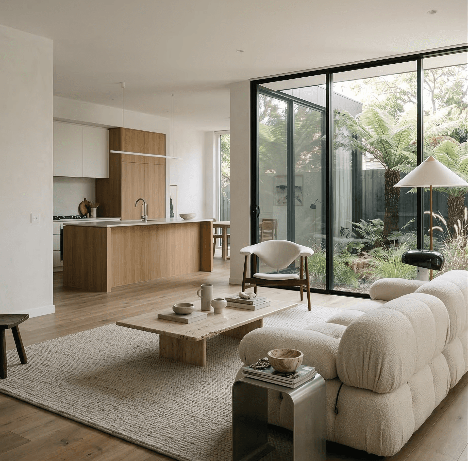 Beige interior with natural stone walls, sunlight, and geometric shadows over a calm water pool.